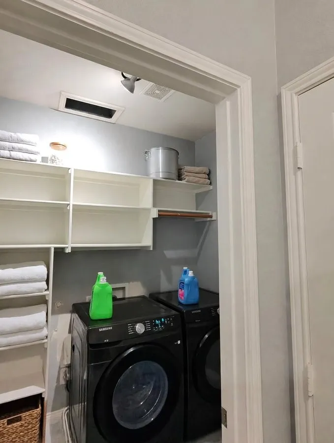 Built-in shelving units, track lighting, and a hanging rod provide ample storage and functionality