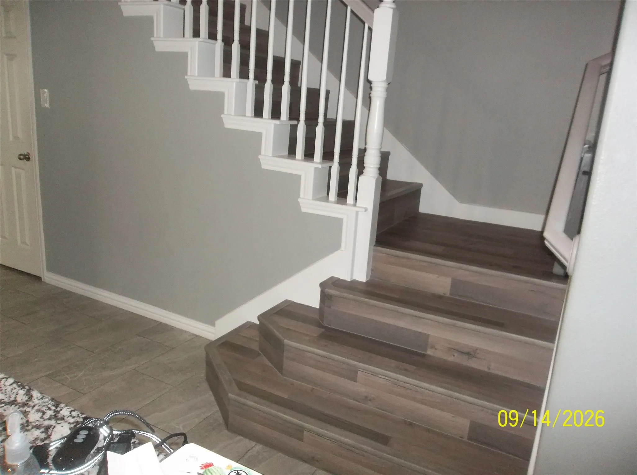 Staircase featuring wood-finish treads and white balusters