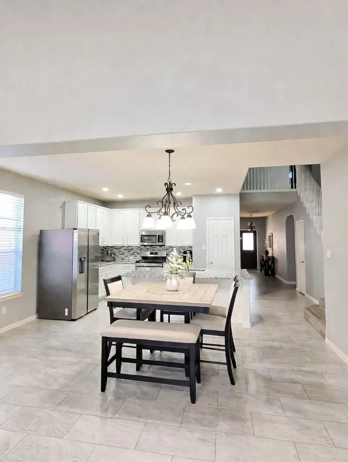 Kitchen featuring white cabinetry, stainless steel appliances, a tile backsplash, and recessed lighting