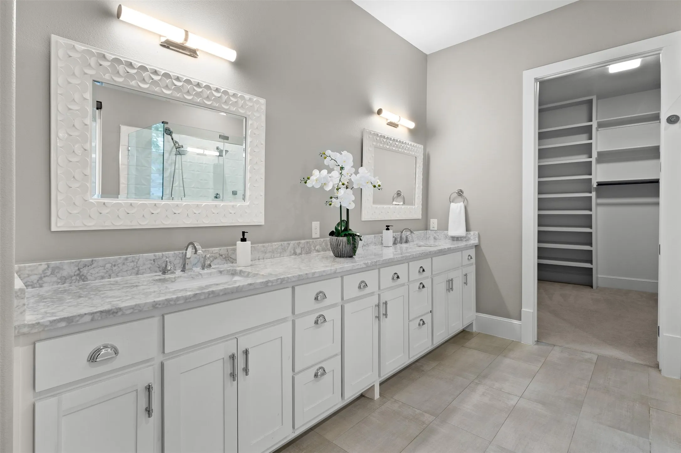 Dual vanity with undermount sinks, stone countertops, and chrome fixtures
