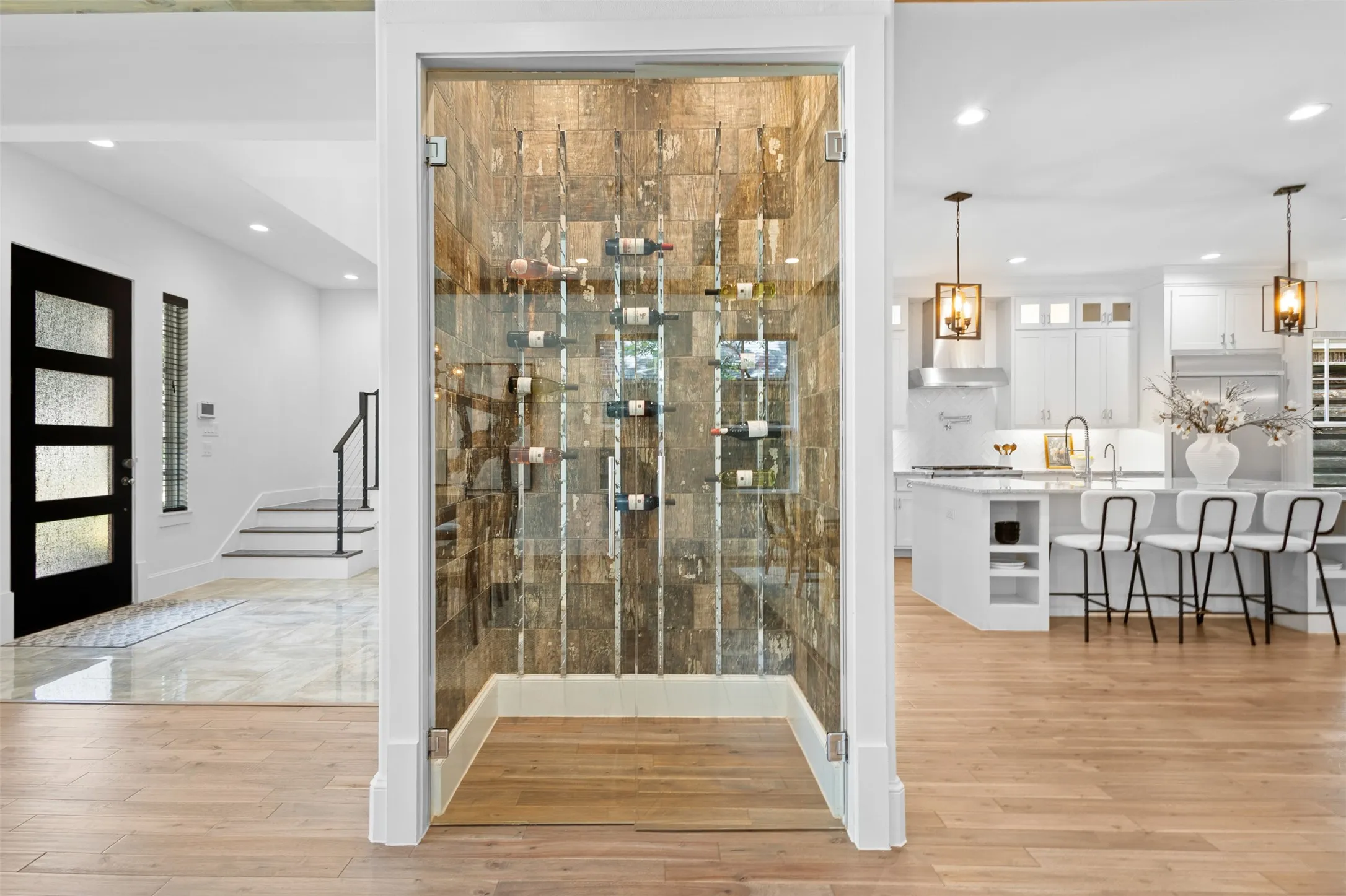 Glass-enclosed wine storage with stone-tiled accent wall