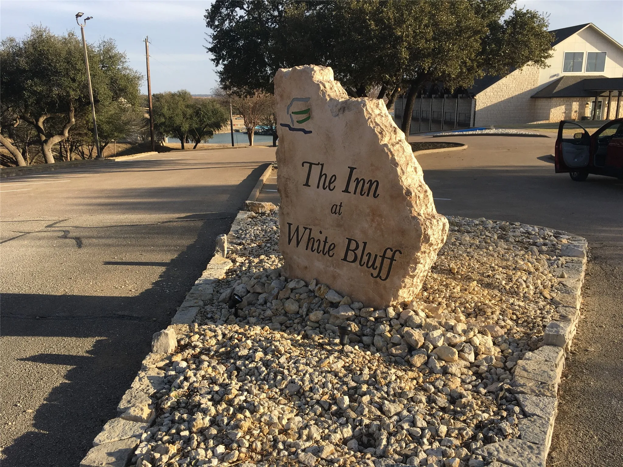 Stone-clad entry sign featuring a natural stone base, surrounded by gravel landscaping