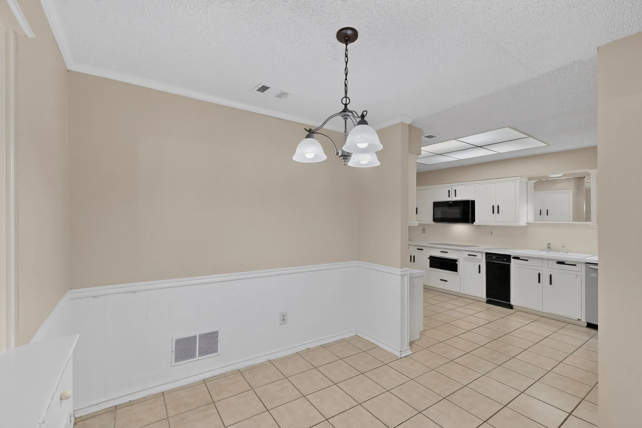 Kitchen featuring white cabinetry, built-in microwave, and tile flooring