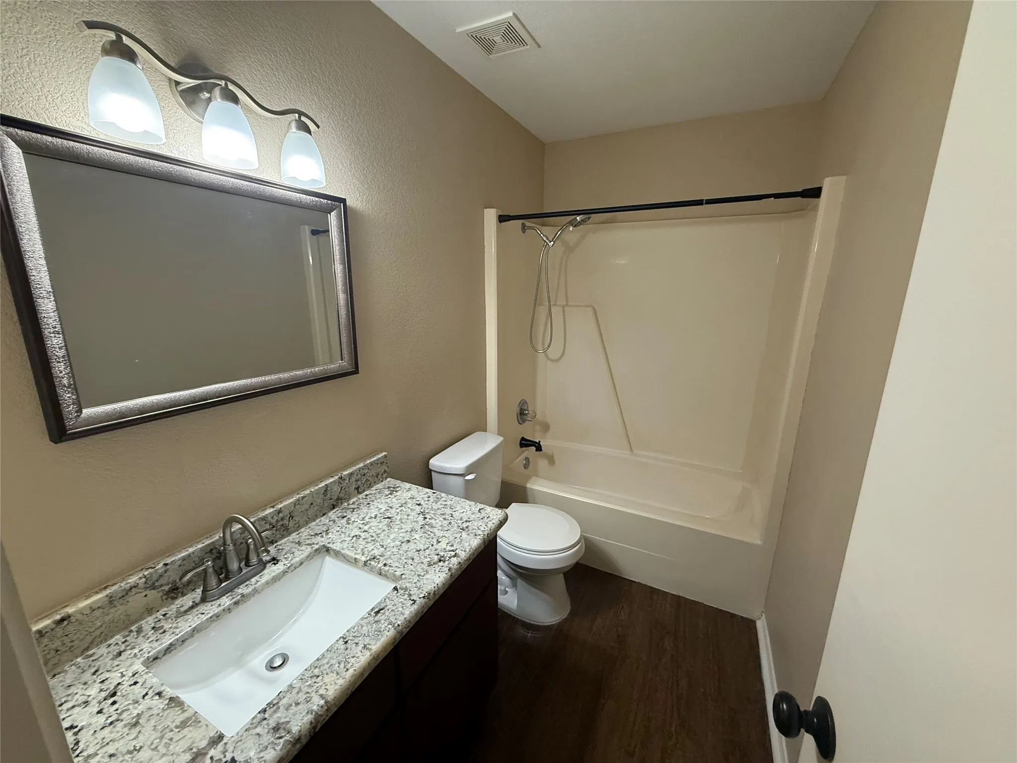 Vanity with granite countertop, integrated sink, and brushed nickel faucet