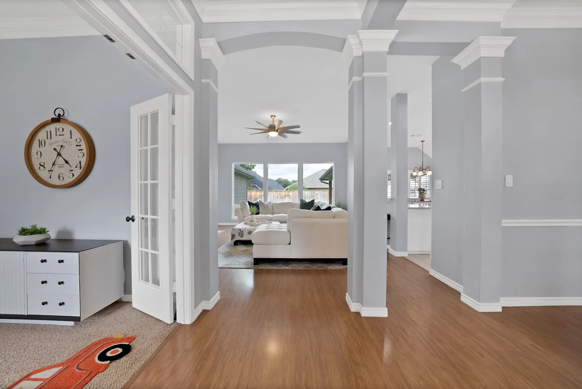 Wood-finish flooring throughout, featuring a coffered ceiling and arched entryways