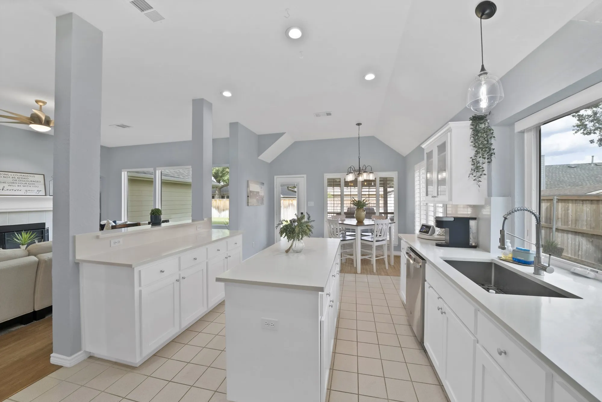 Kitchen featuring white cabinetry, light-toned countertops, and an undermount sink with a gooseneck faucet