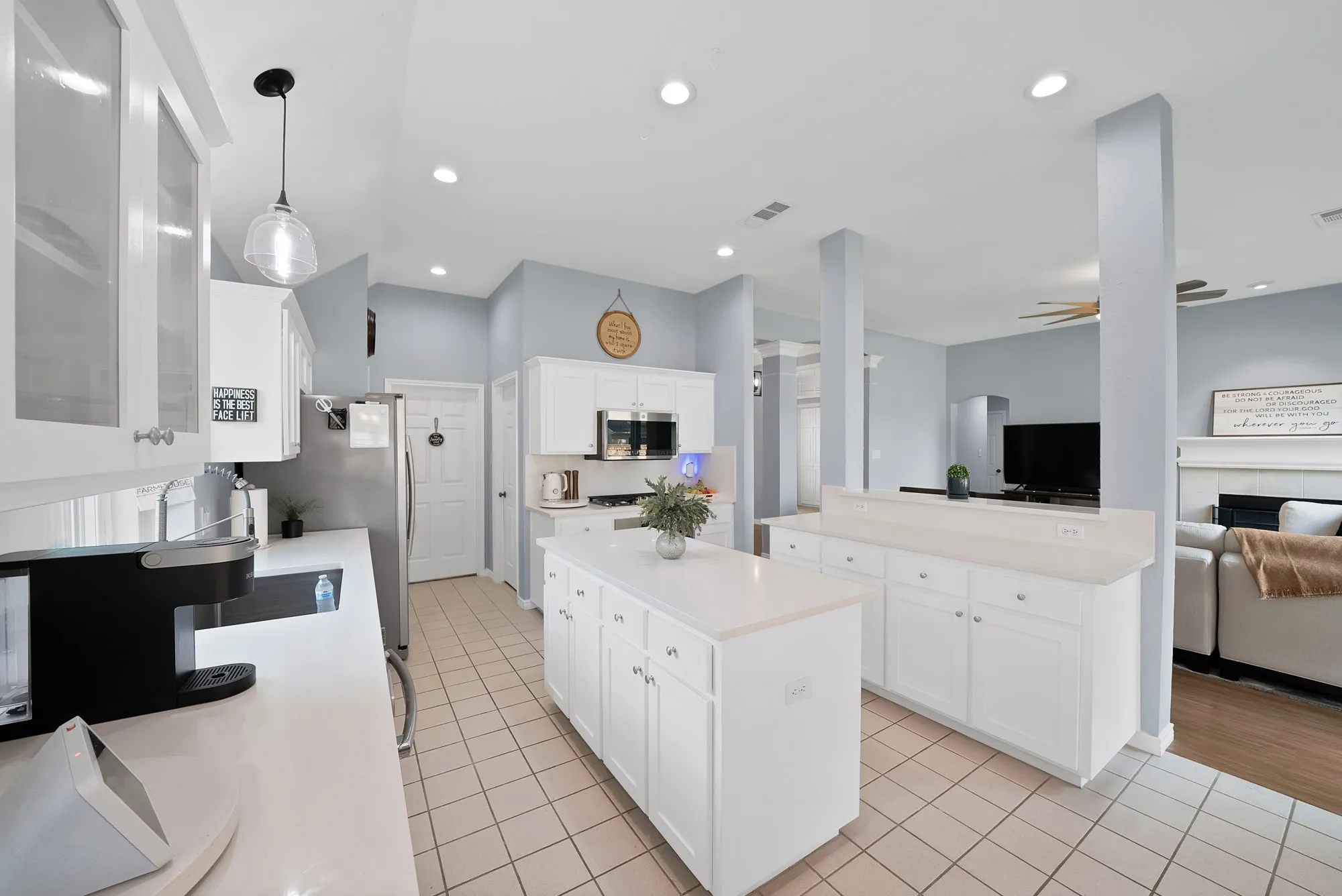Open-concept kitchen with white cabinetry, tile flooring, a central island, recessed lighting, and a breakfast bar