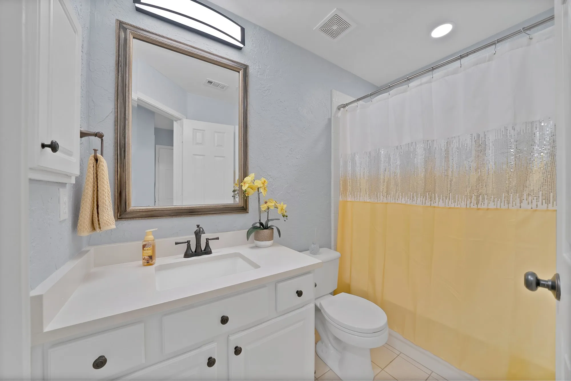White vanity with an integrated sink, dark bronze-finish faucet, and coordinating hardware
