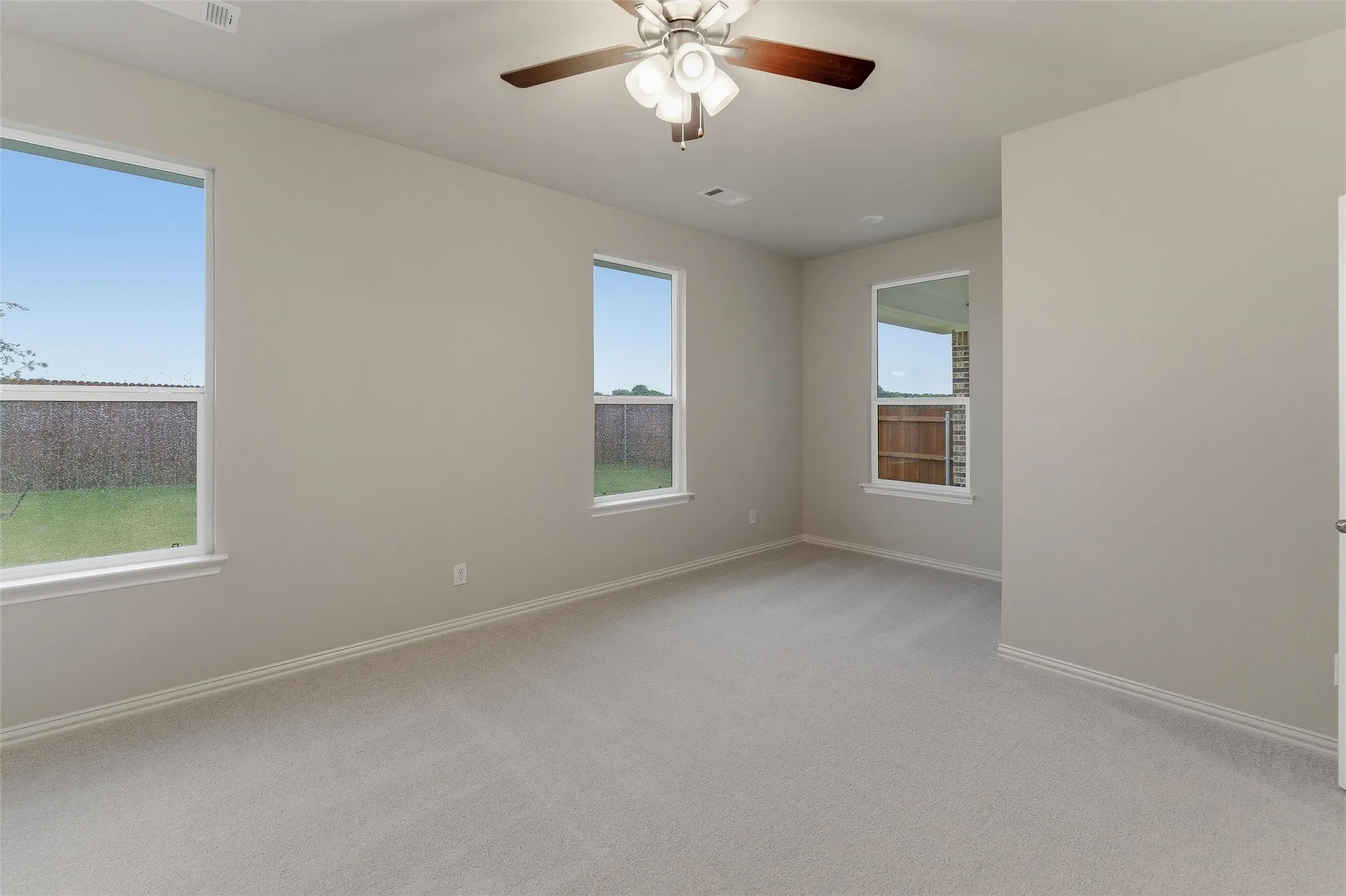 Spacious room featuring neutral carpeting and light-toned walls