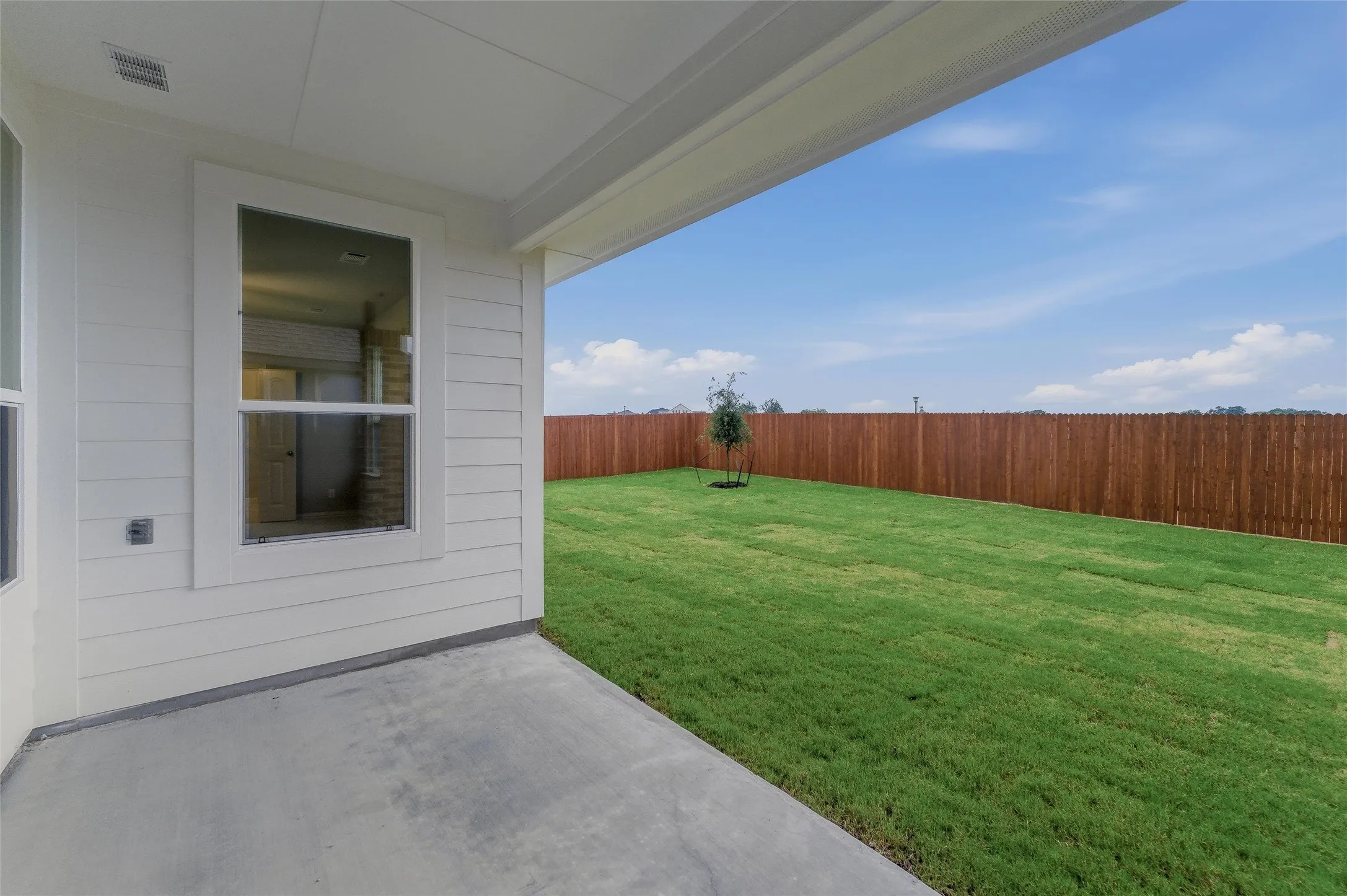 Expansive backyard featuring a manicured lawn and a privacy fence