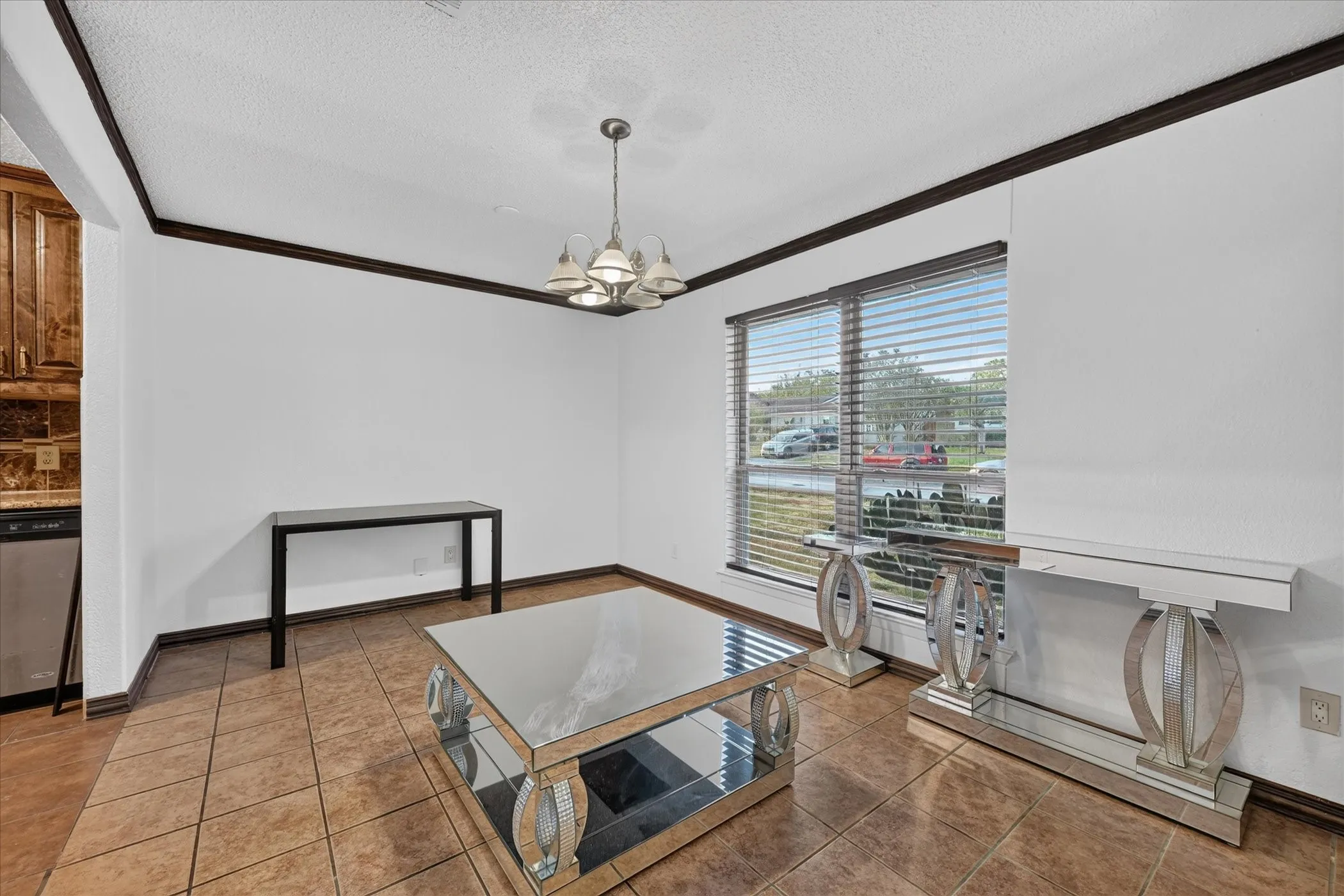White walls with dark crown molding, tile flooring, and a window with blinds