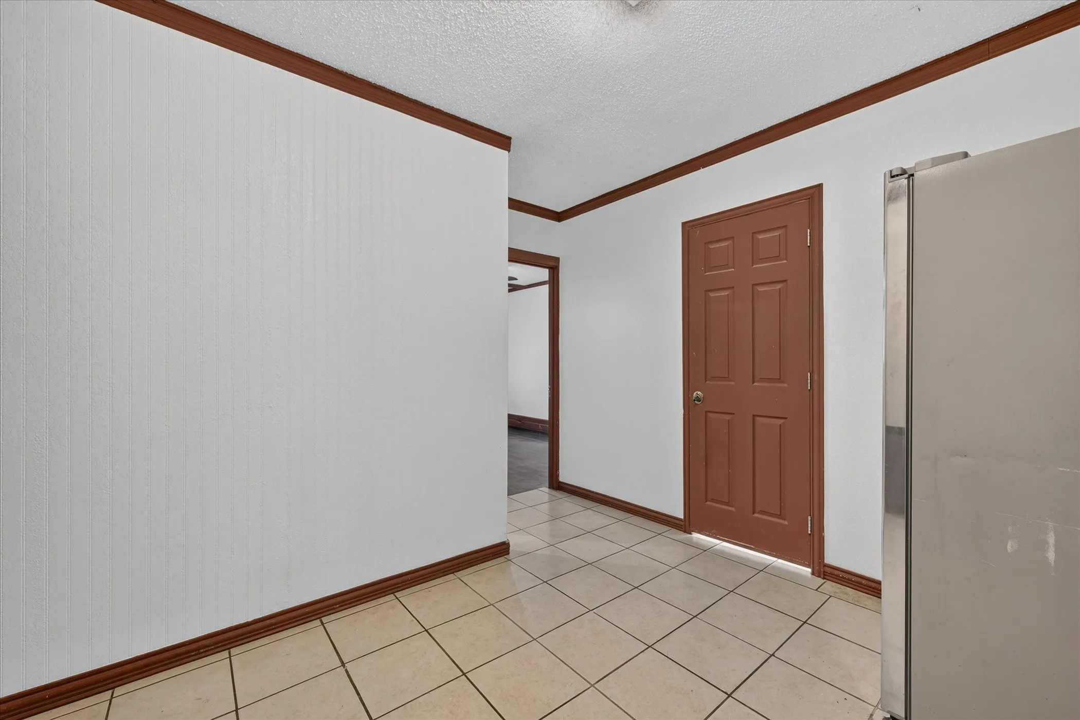 Tile flooring, white walls, wood trim, panel door