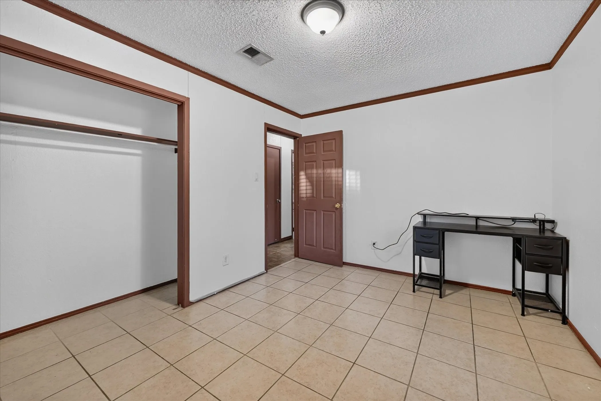 Neutral-toned tile flooring, white walls, and wood-finish trim throughout