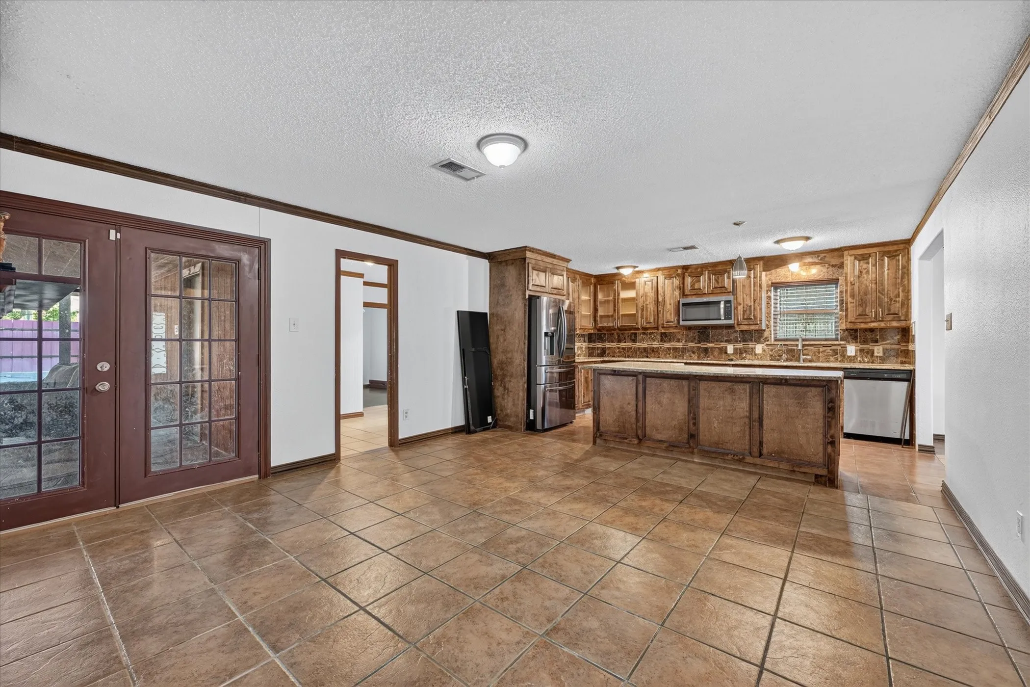 Kitchen featuring wood-finish cabinetry, stainless steel appliances, and a central island with countertop