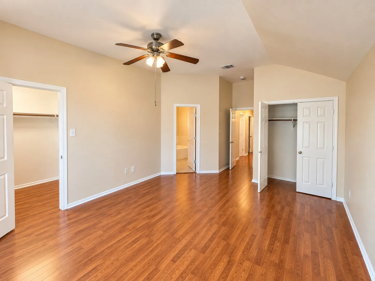 Wood-finish flooring, vaulted ceiling, and a ceiling fan with integrated lighting