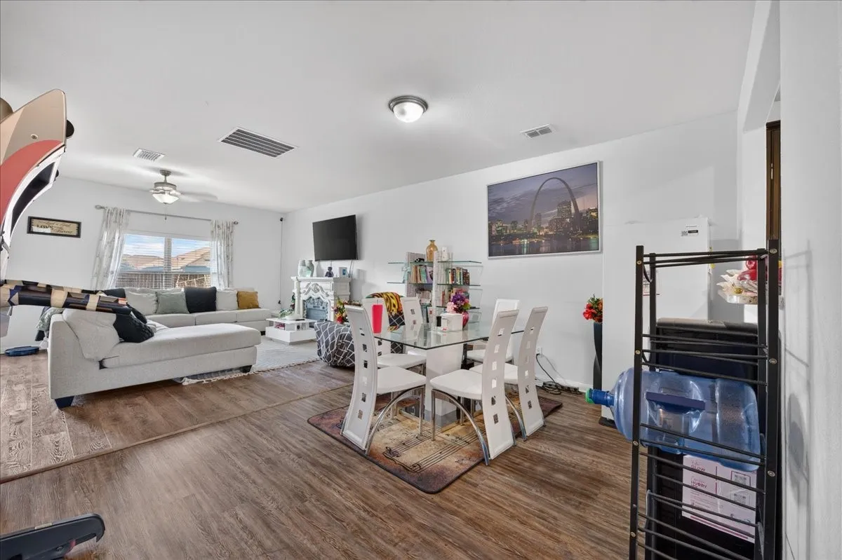 Open-concept living space with wood-finish flooring, recessed lighting, and a ceiling fan