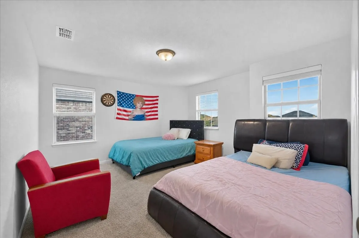 Carpeted room with multiple windows providing natural light