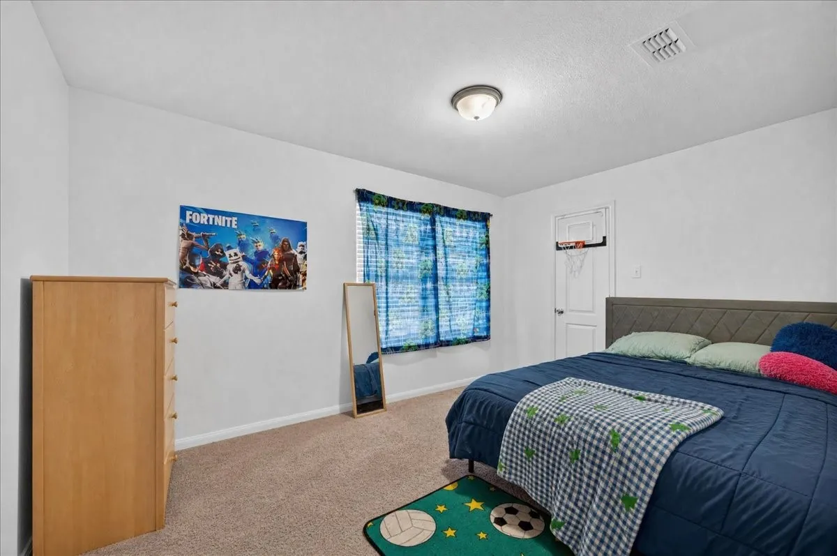 Carpeted flooring, white walls, window with blinds, and a ceiling-mounted light fixture