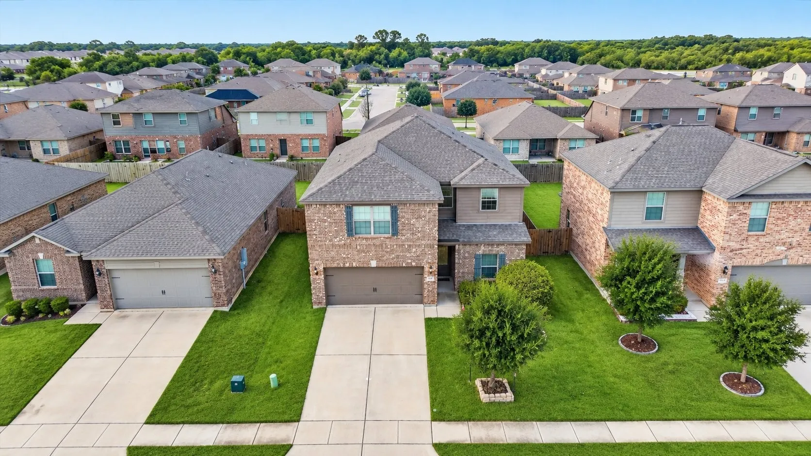Two-story home featuring a brick and siding exterior, an attached two-car garage, and a concrete driveway
