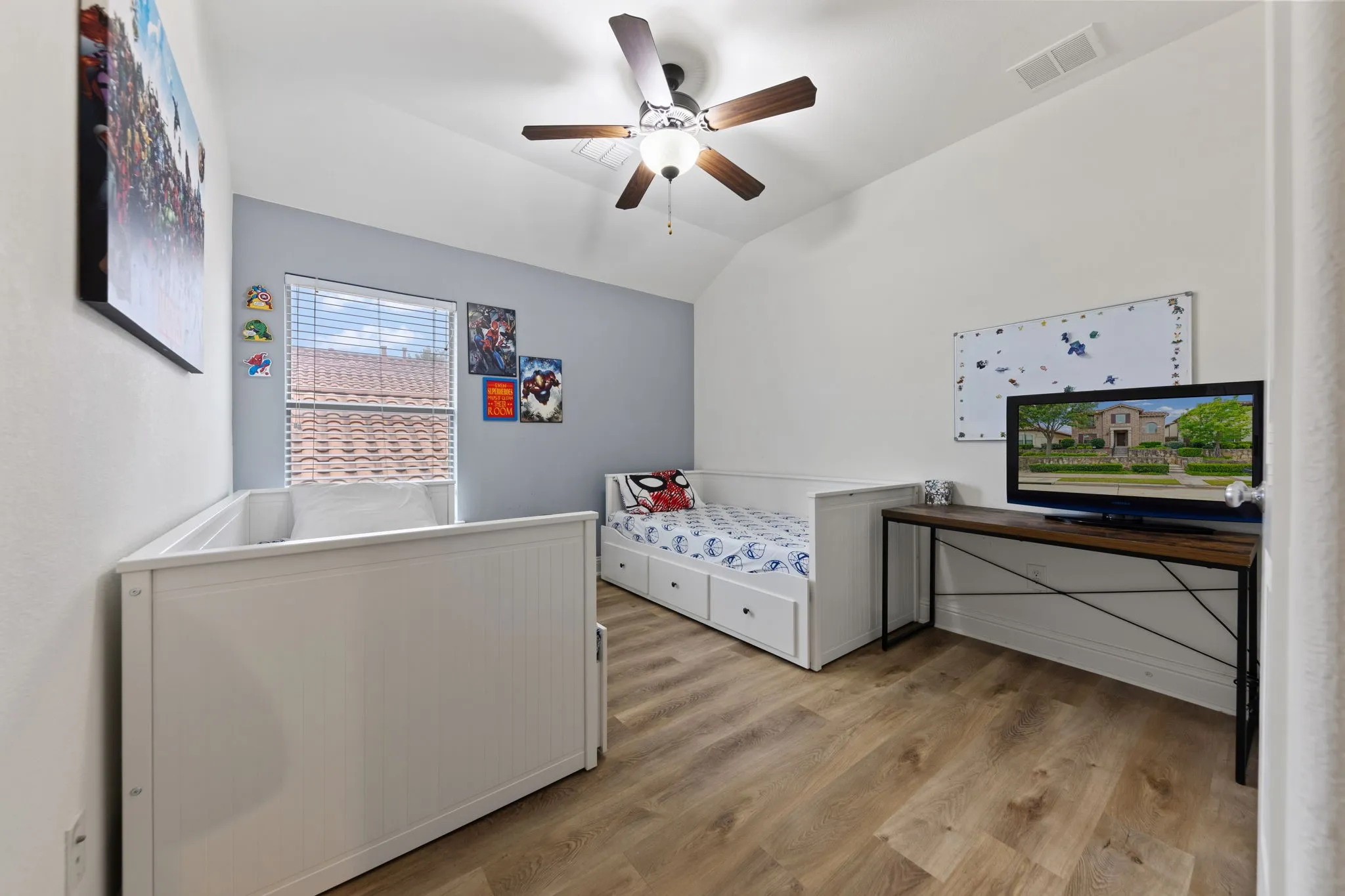 Vaulted ceiling with a ceiling fan, wood-finish flooring, and a window with blinds