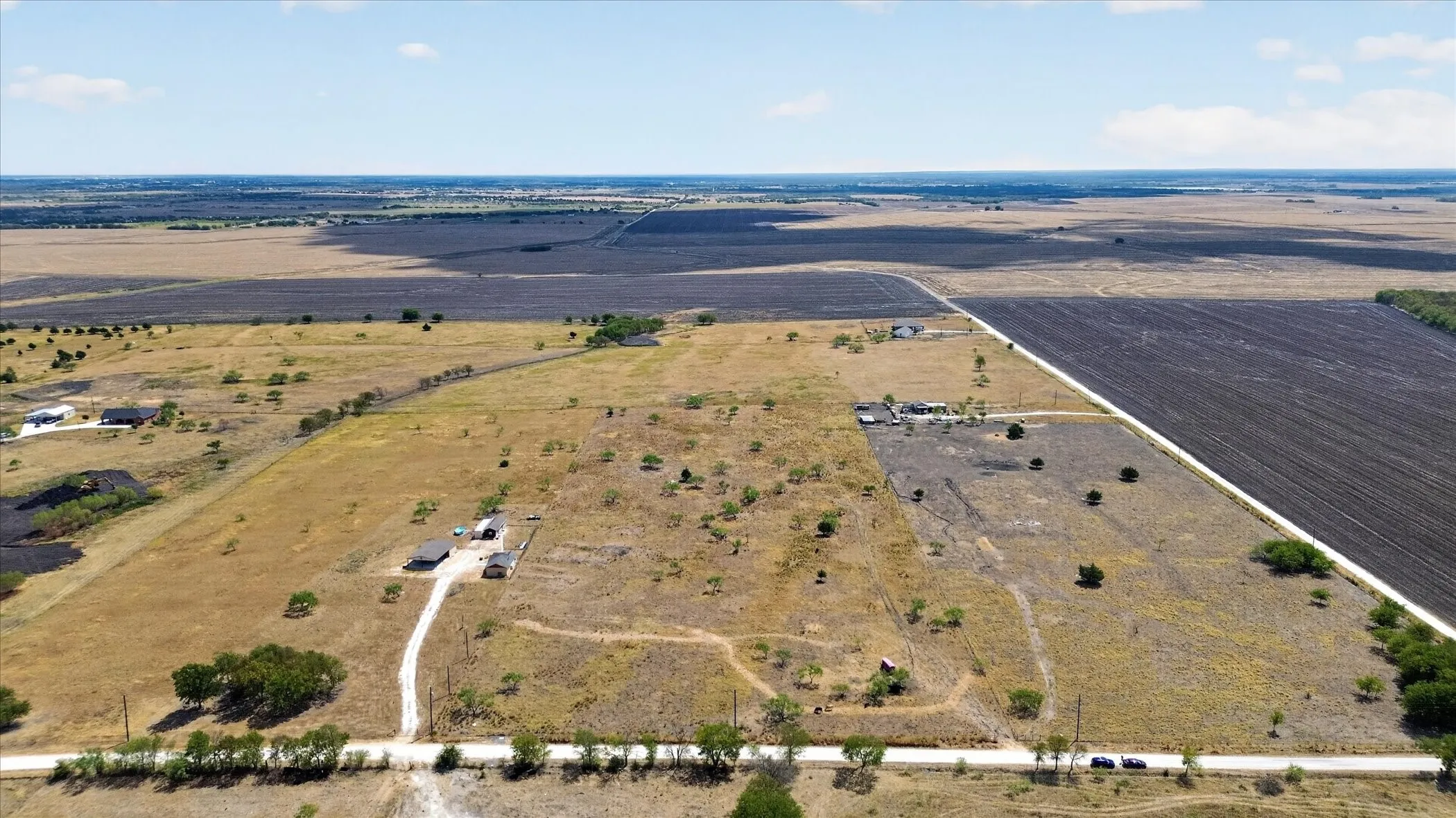 Expansive rural landscape with a mix of cultivated fields and uncultivated land