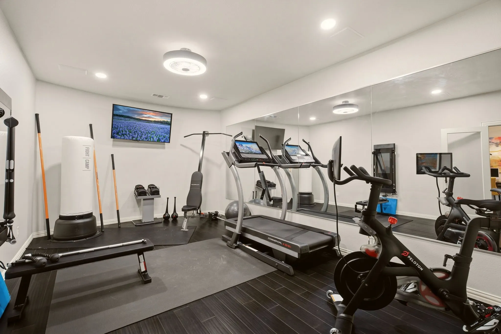 The private home gym, an addition to the home in 2021, is accessed through opaque-glass French doors and offers an impressive 317 square feet of dedicated workout space.