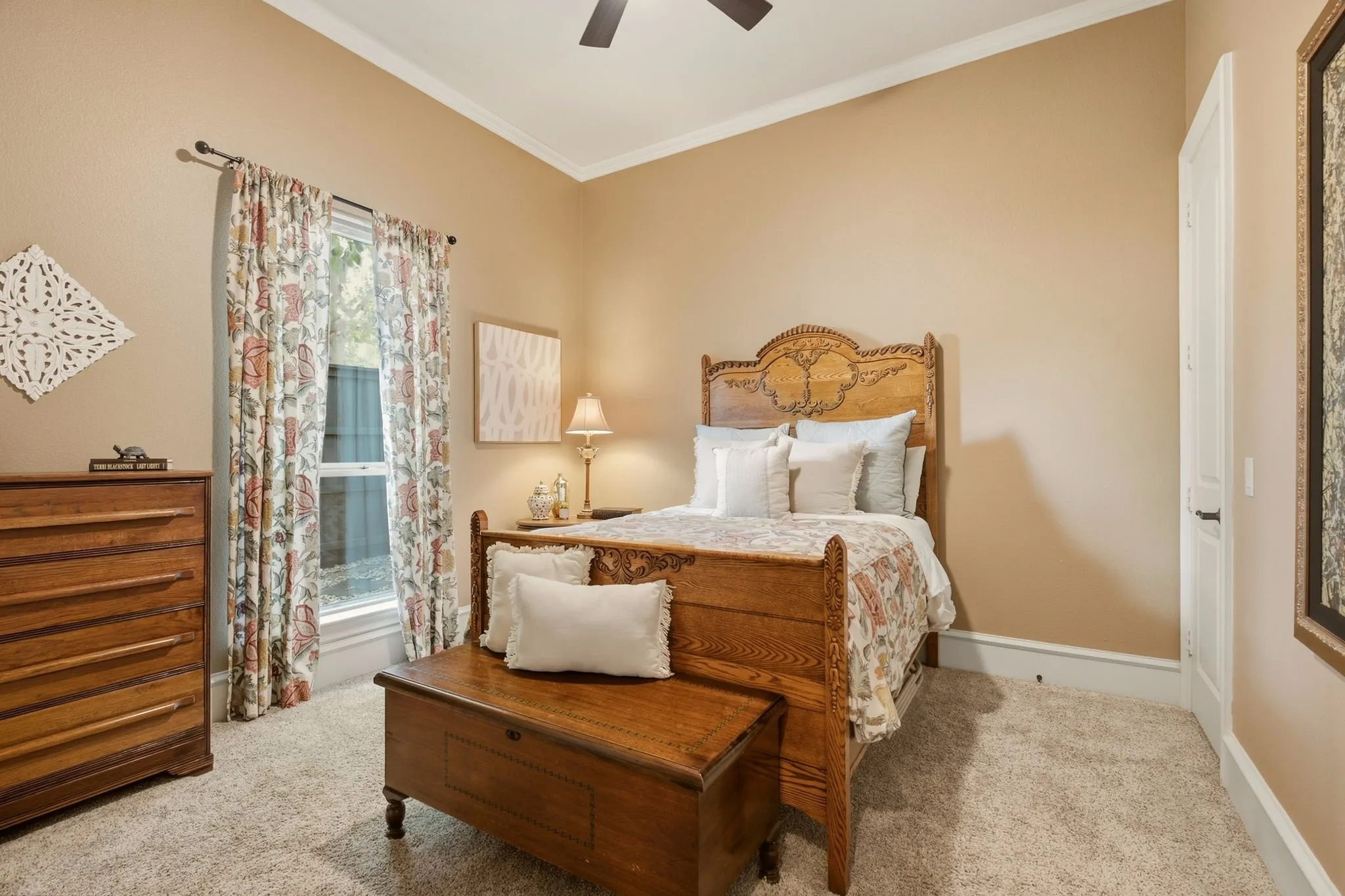 The first-floor guest suite offers a comfortable retreat, featuring new plush carpeting, elegant crown molding, and a ceiling fan. An oversized walk-in closet provides abundant storage, enhanced by additional under-stair storage for added convenience. Direct access to the en suite bathroom creates a private and comfortable experience for overnight guests.
