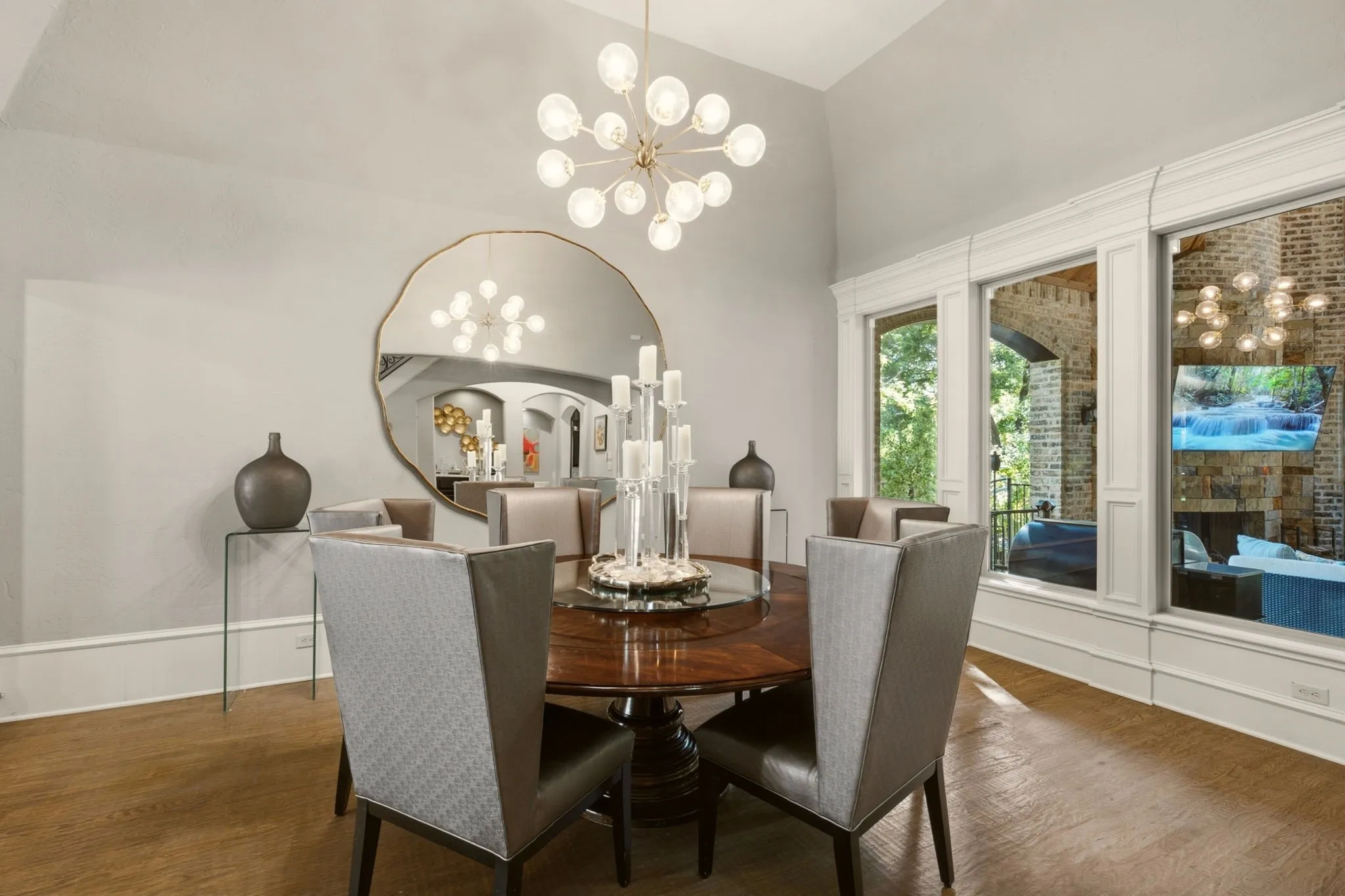 Sophisticated Formal Dining Room with Dramatic 16-inch bright-white baseboards make a striking architectural statement, complemented by a stunning designer Sputnik chandelier with glass-and-soft-gold accents.