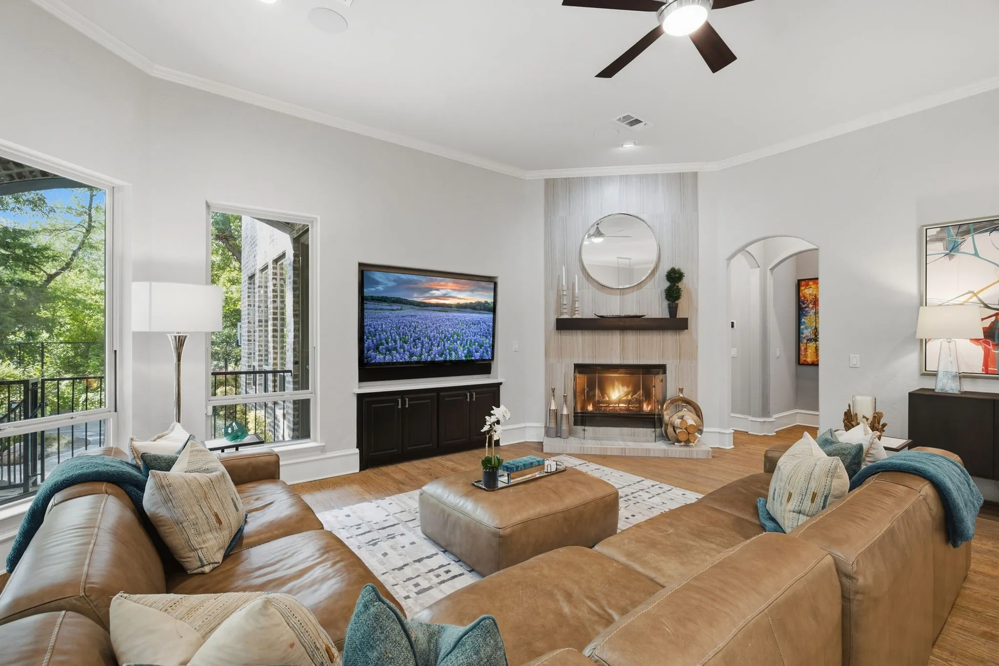 The spacious living room creates an inviting gathering space for both everyday living and entertaining, thoughtfully designed around a dramatic floor-to-ceiling gas fireplace.