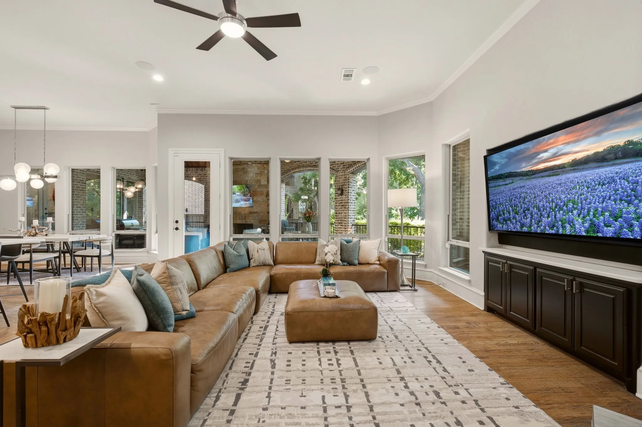 Natural toned hardwood floors extend throughout, complemented by custom built-in cabinetry and a dedicated niche perfectly sized for a flat-screen TV.