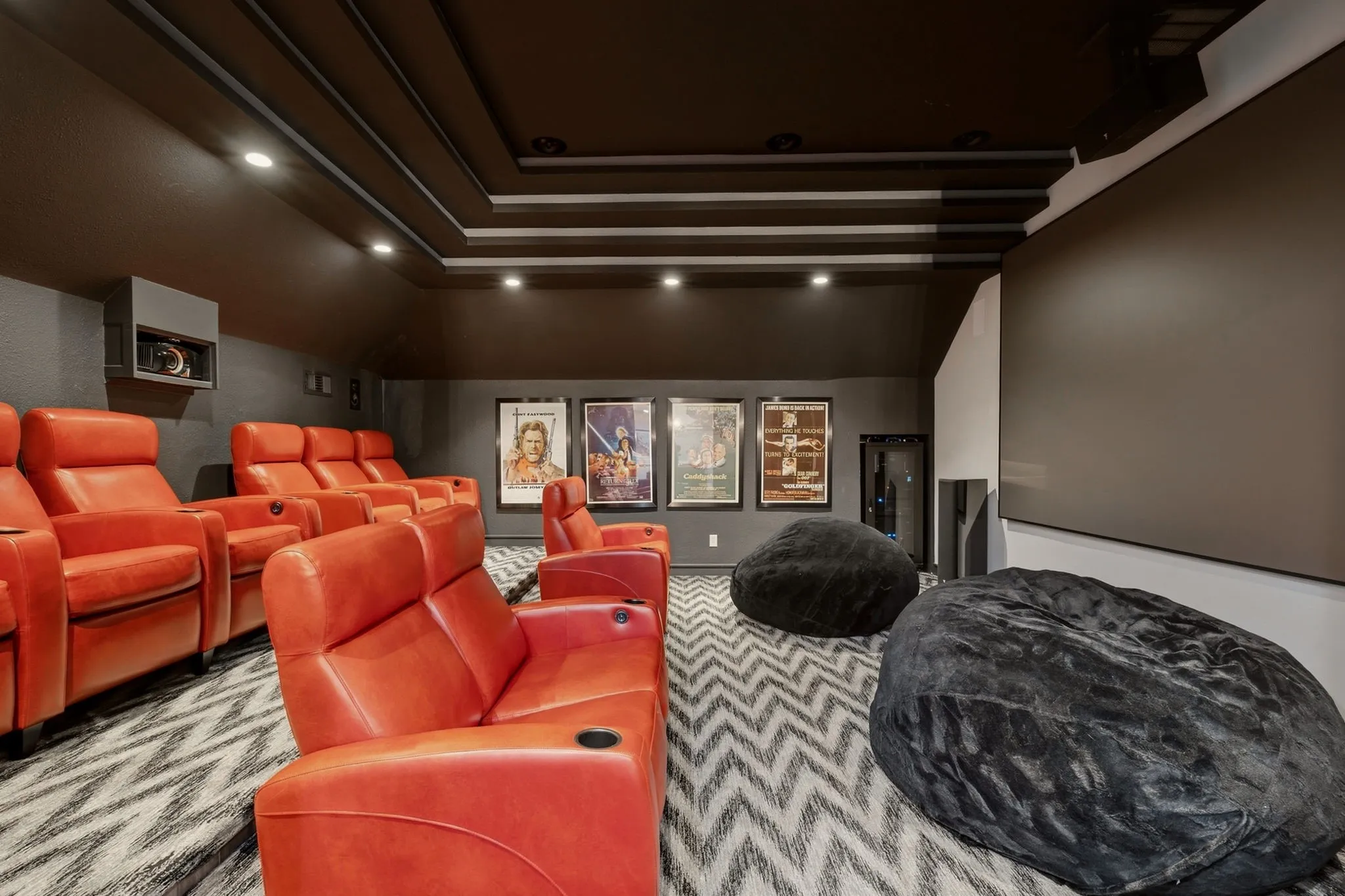 Sliding pocket barn doors open to the recently renovated two-tiered, fully equipped media room that delivers a true cinematic experience, thoughtfully designed for immersive movie nights and unforgettable entertaining.