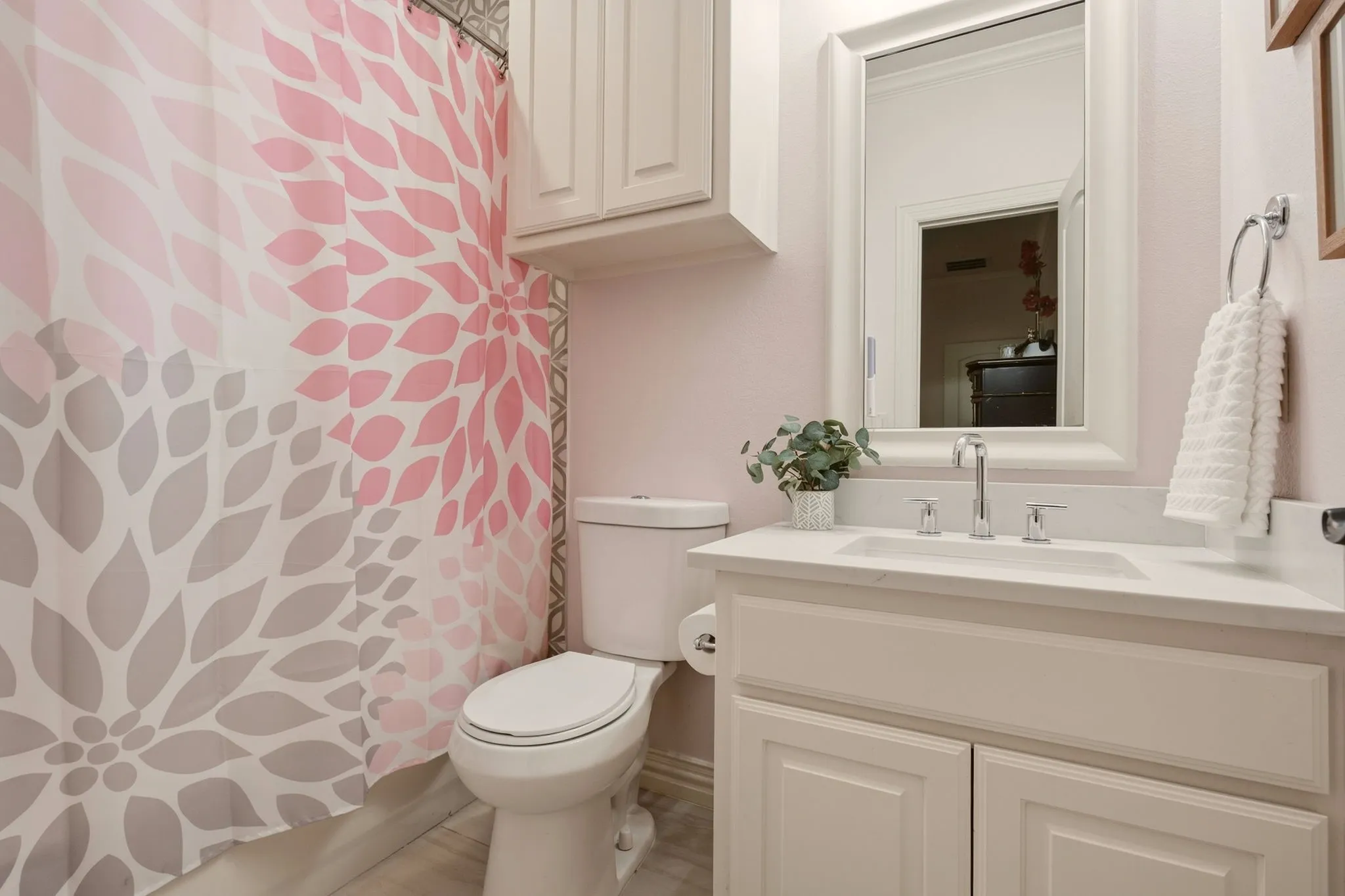 The recently renovated en suite bathroom connected to Bedroom 5 combines playful design with elevated everyday functionality. Tile flooring complements a built-in vanity topped with quartz countertops, an undermount sink, and brushed-nickel faucets and fixtures, while upper cabinetry provides additional storage.
