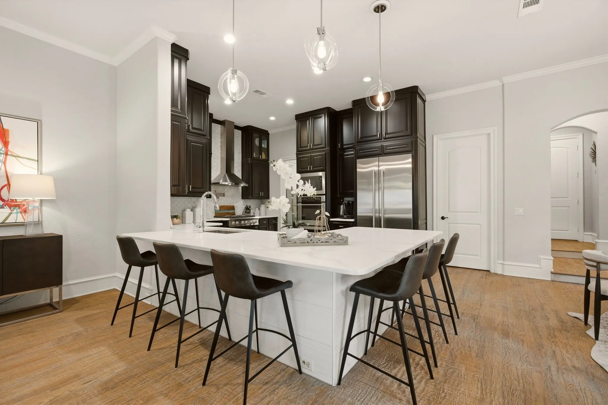 The gourmet kitchen is one you won’t forget, recently renovated with oversized tile flooring and floor-to-ceiling walnut cabinetry, accented by brushed-nickel hardware and elegant crown molding.
