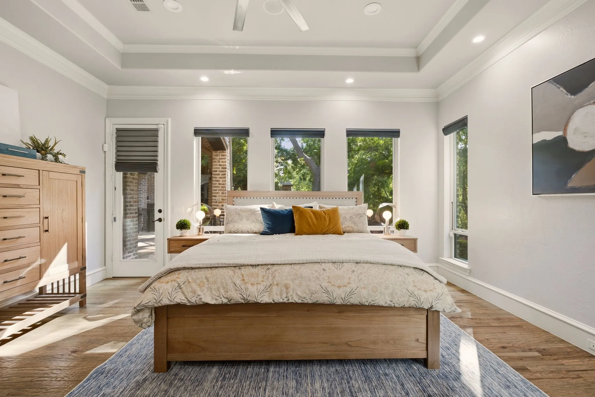 Five expansive windows showcase captivating views of the pool and spa with cascading waterfall and the adjacent sport court, while a glass exterior door provides private, direct access to the backyard.