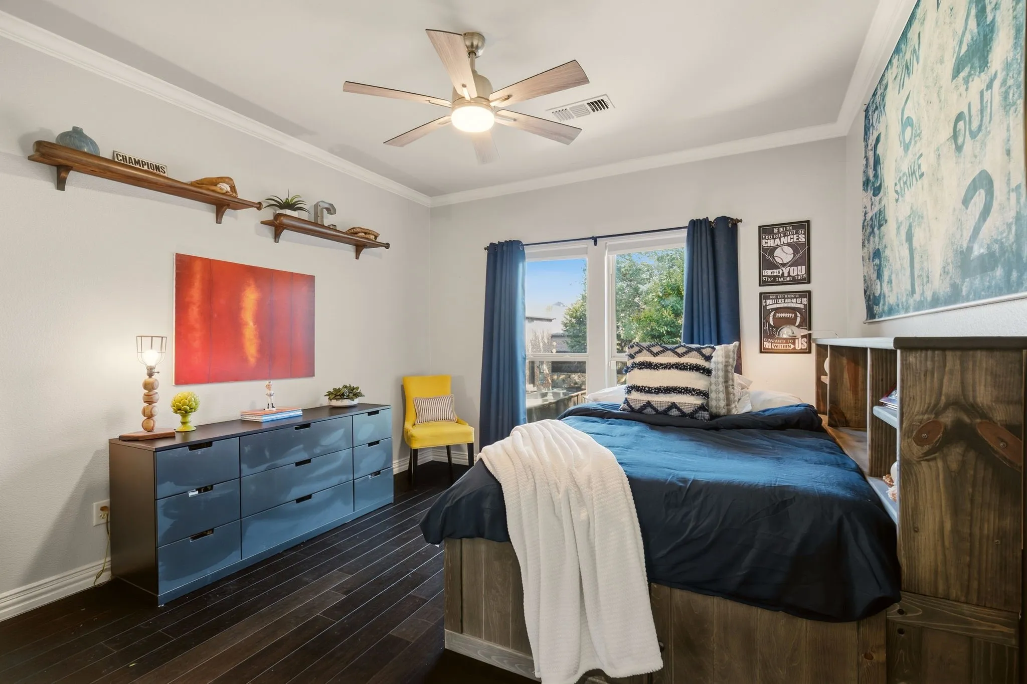 Bedroom 3, located on the second floor, features warm wood floors, crown molding, and a ceiling fan. A large window overlooks the front yard and peaceful cul-de-sac, filling the room with natural light. The spacious walk-in closet includes built-in shelving for organized storage, while a private, recently renovated vanity area offers a built-in vanity and sink with direct access to the Jack-and-Jill bathroom.
