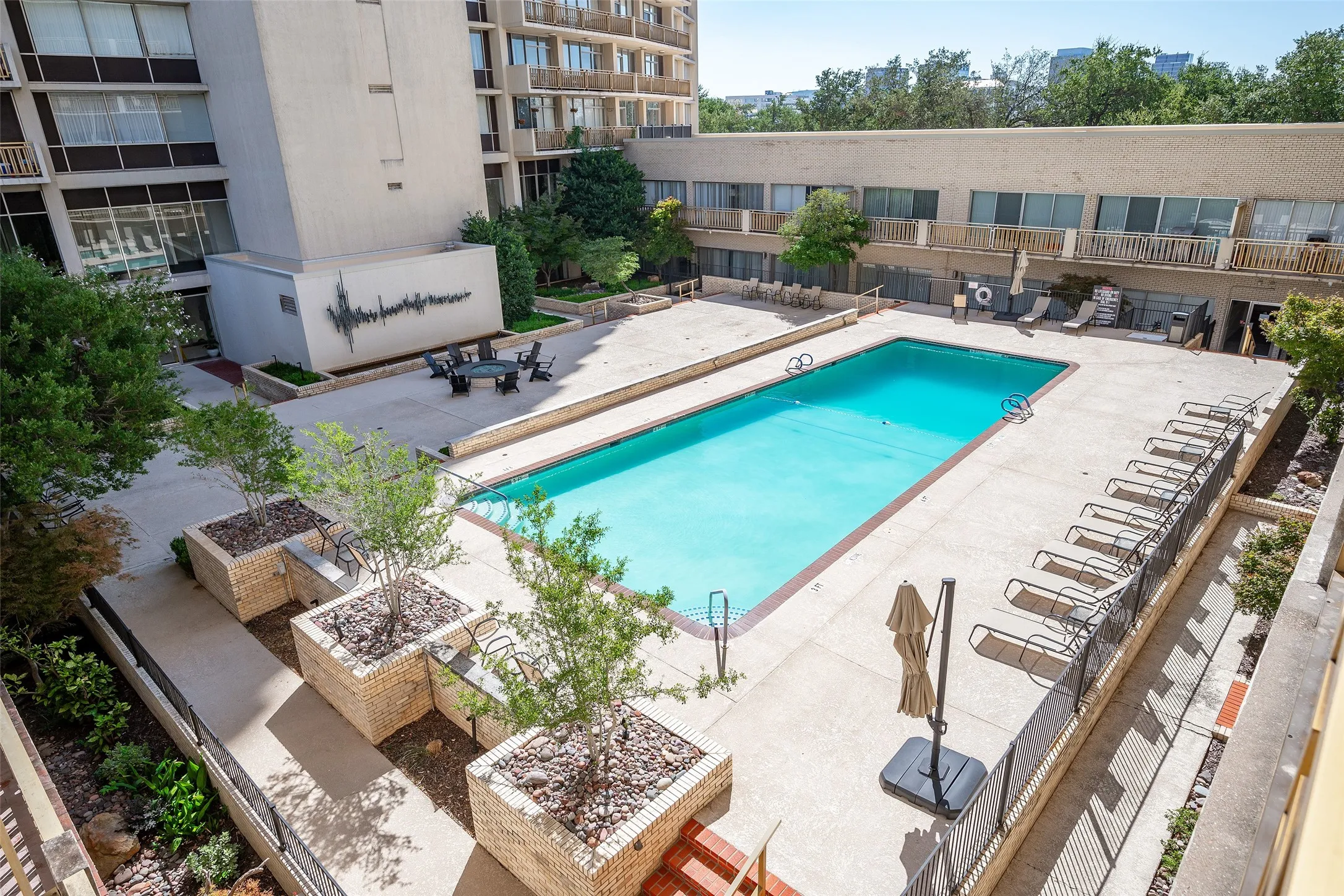Landscaping and chairs invite you to lounge by the pool.