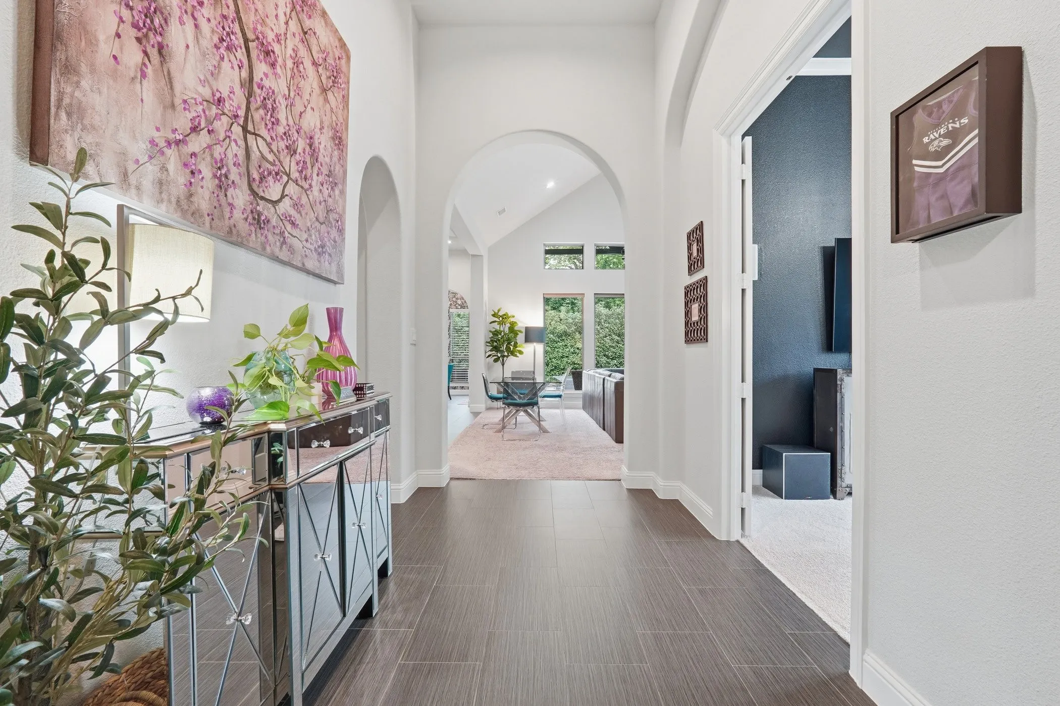 Arched doorways create a grand entrance, complemented by rich wood-finish flooring