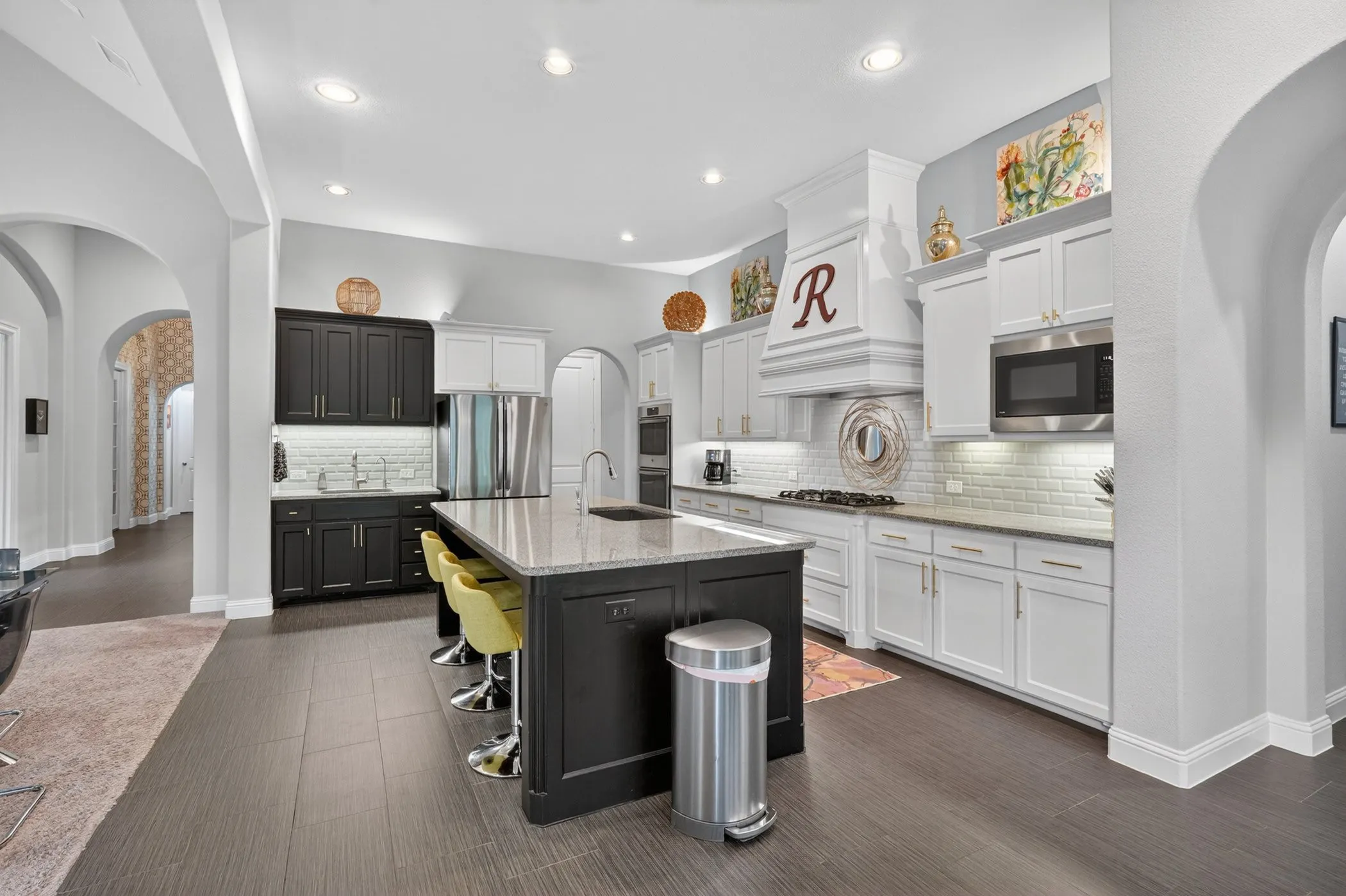 Spacious kitchen featuring an expansive center island, wood-finish flooring, recessed lighting, and a subway tile backsplash
