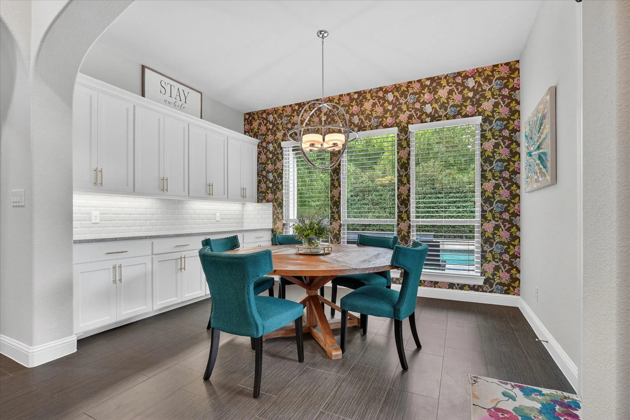 Formal dining area featuring extensive built-in cabinetry, a subway tile backsplash, and dark wood-finish flooring