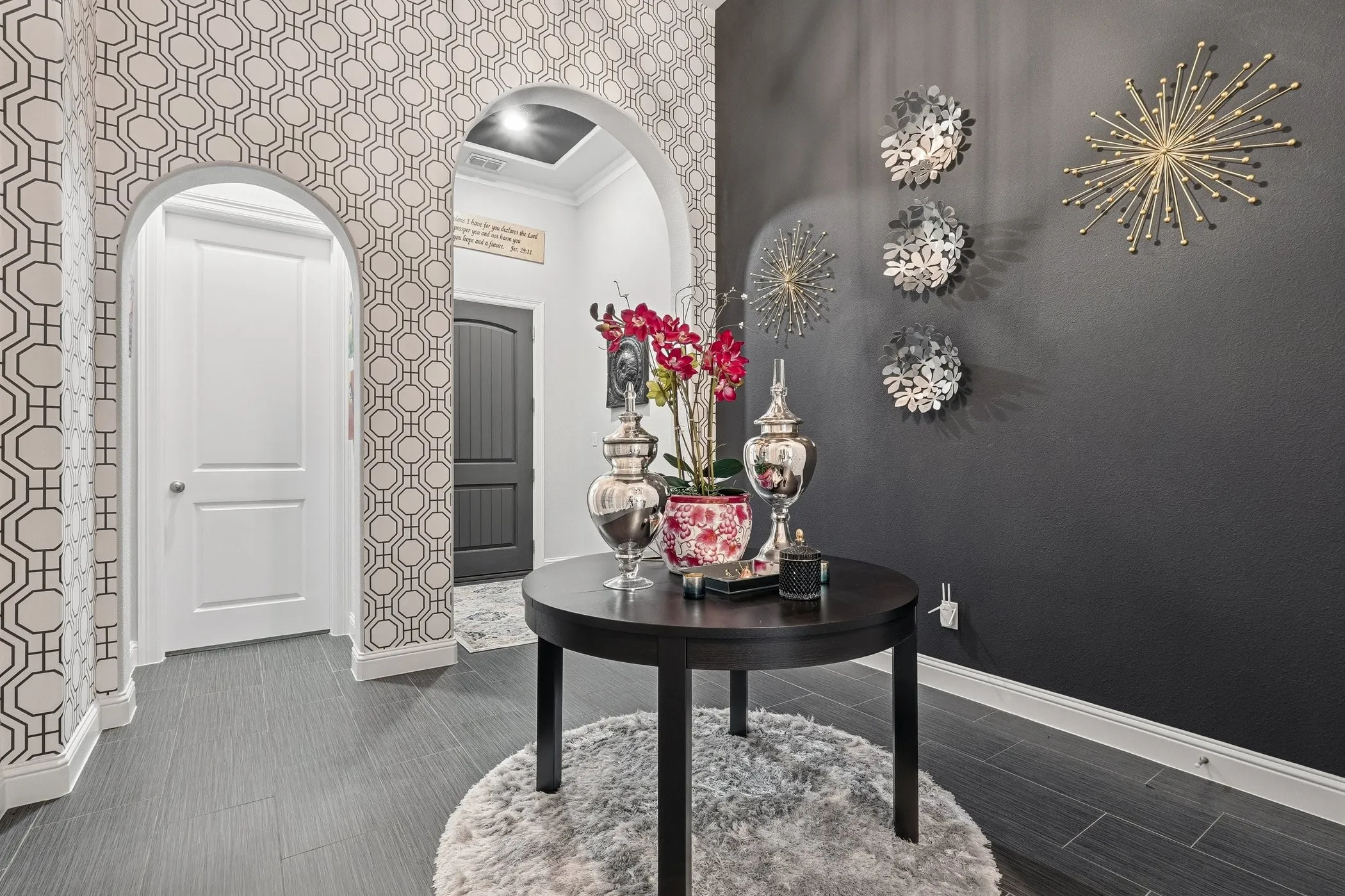 Entryway featuring dark wood-finish flooring and a geometric patterned accent wall