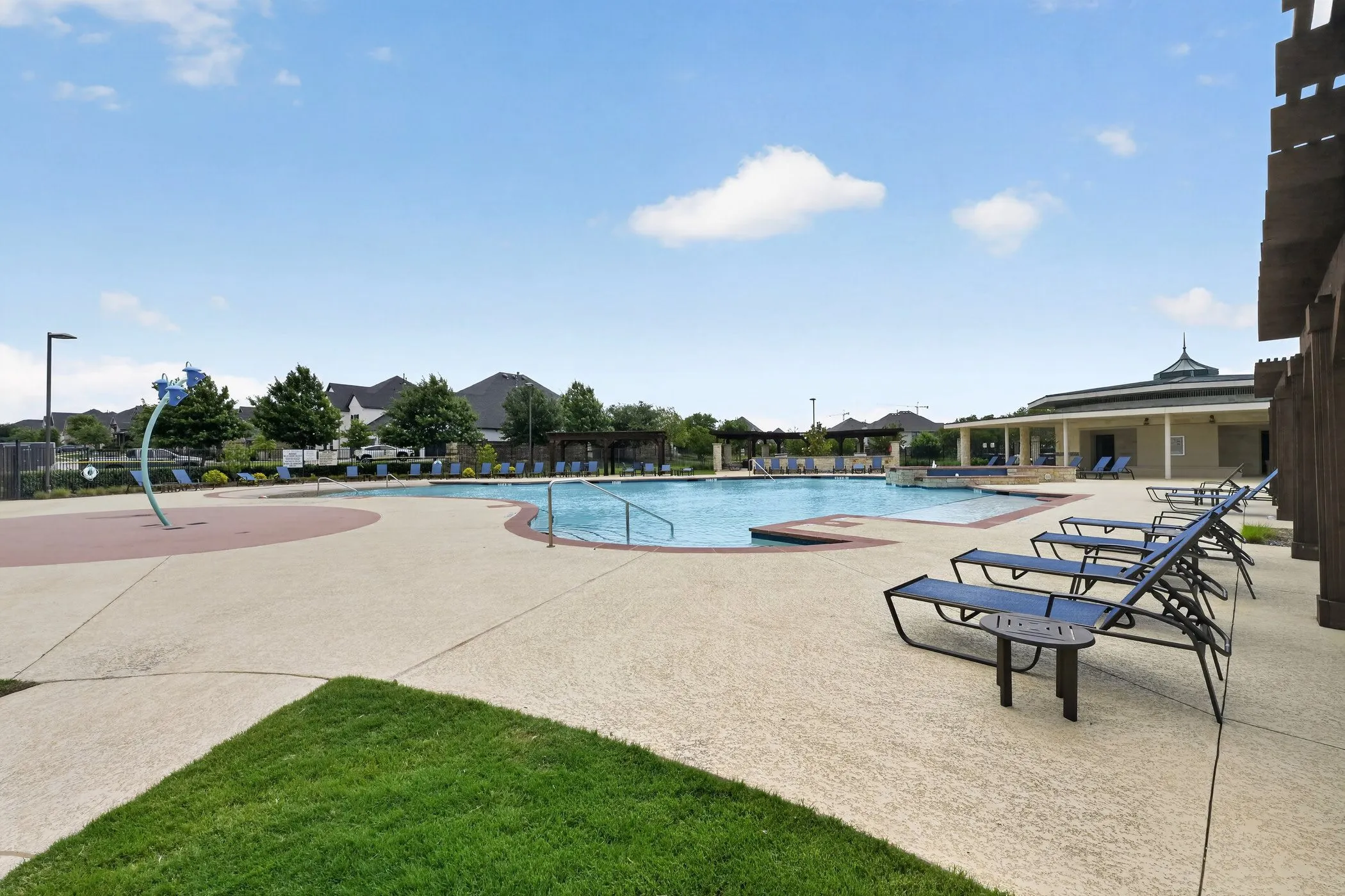 Community swimming pool featuring a curved design and integrated spa