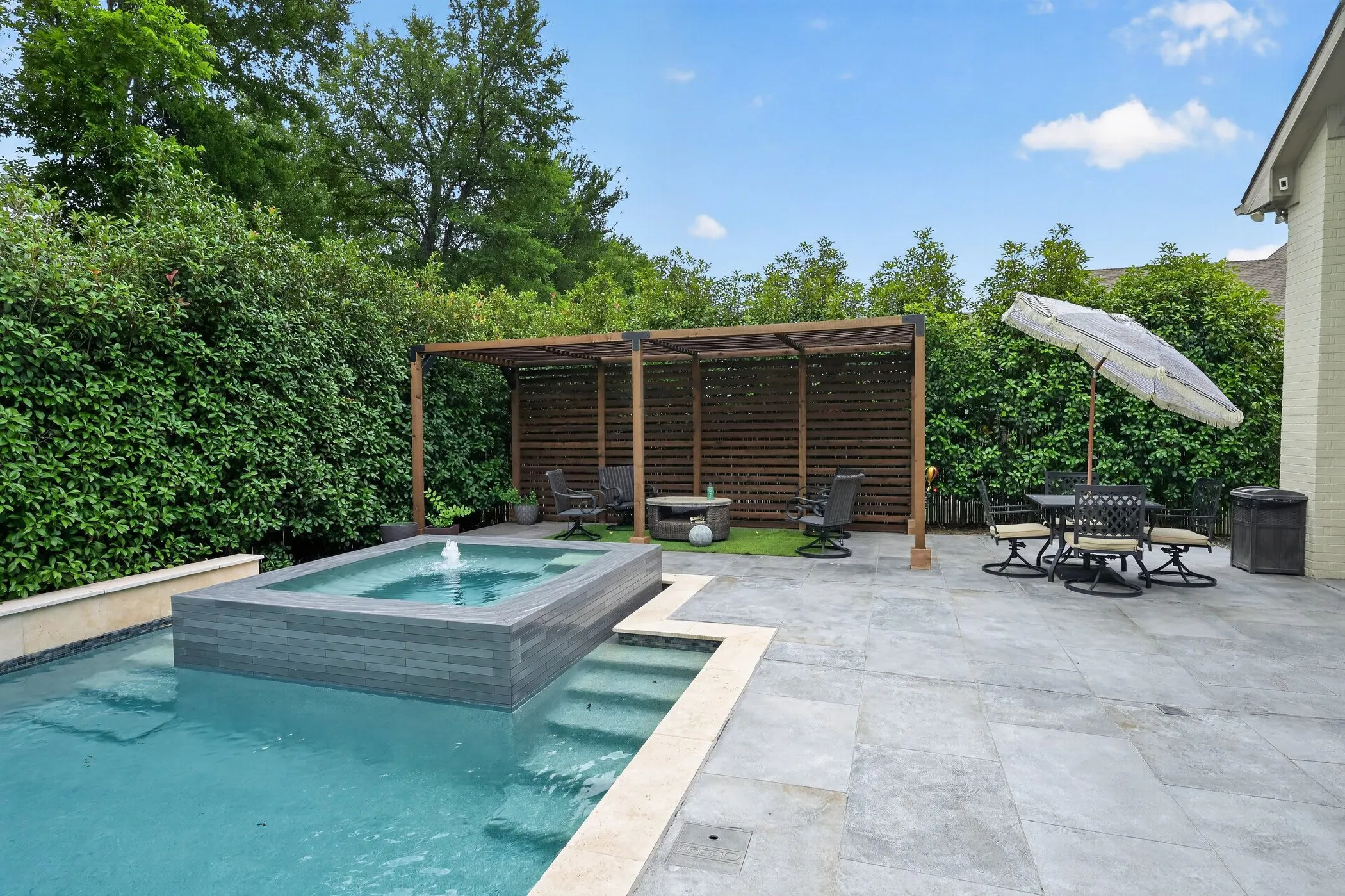 Backyard oasis featuring a swimming pool with integrated spa and fountain