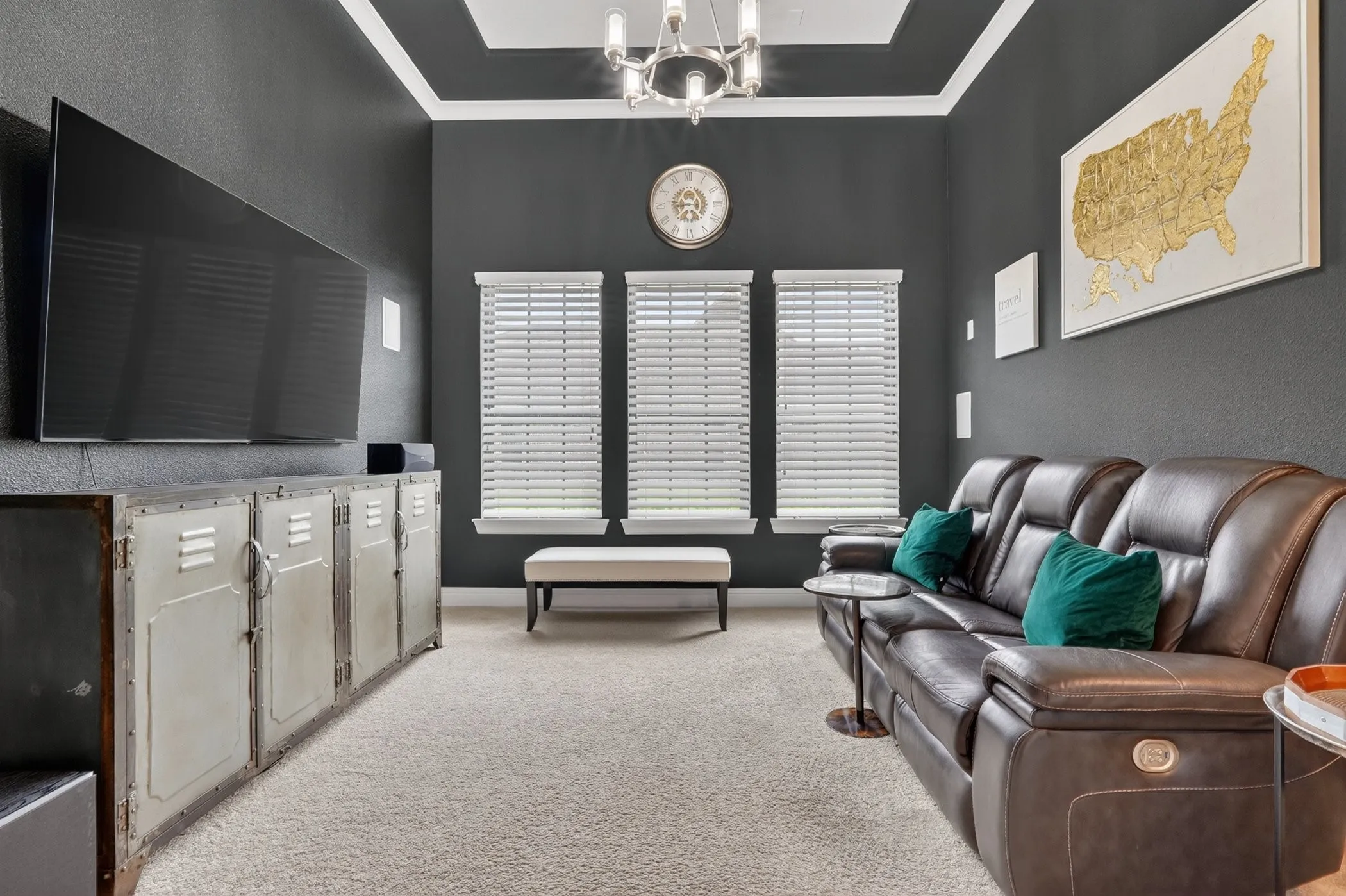 Living space featuring dark accent walls, plush carpeting, and a coffered ceiling with crown molding