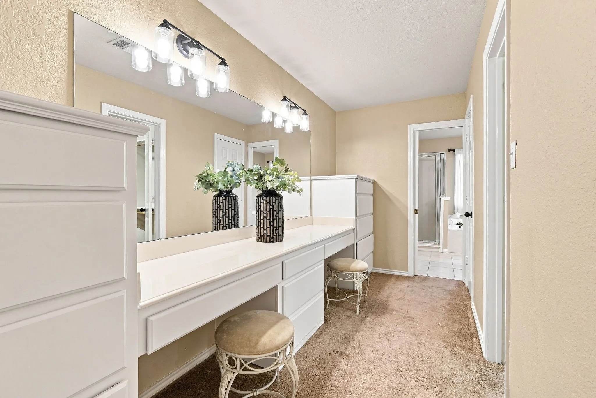Dedicated vanity and get-ready space with a long countertop, statement mirror with vanity lighting, and built-in storage, the perfect spot to start your day.