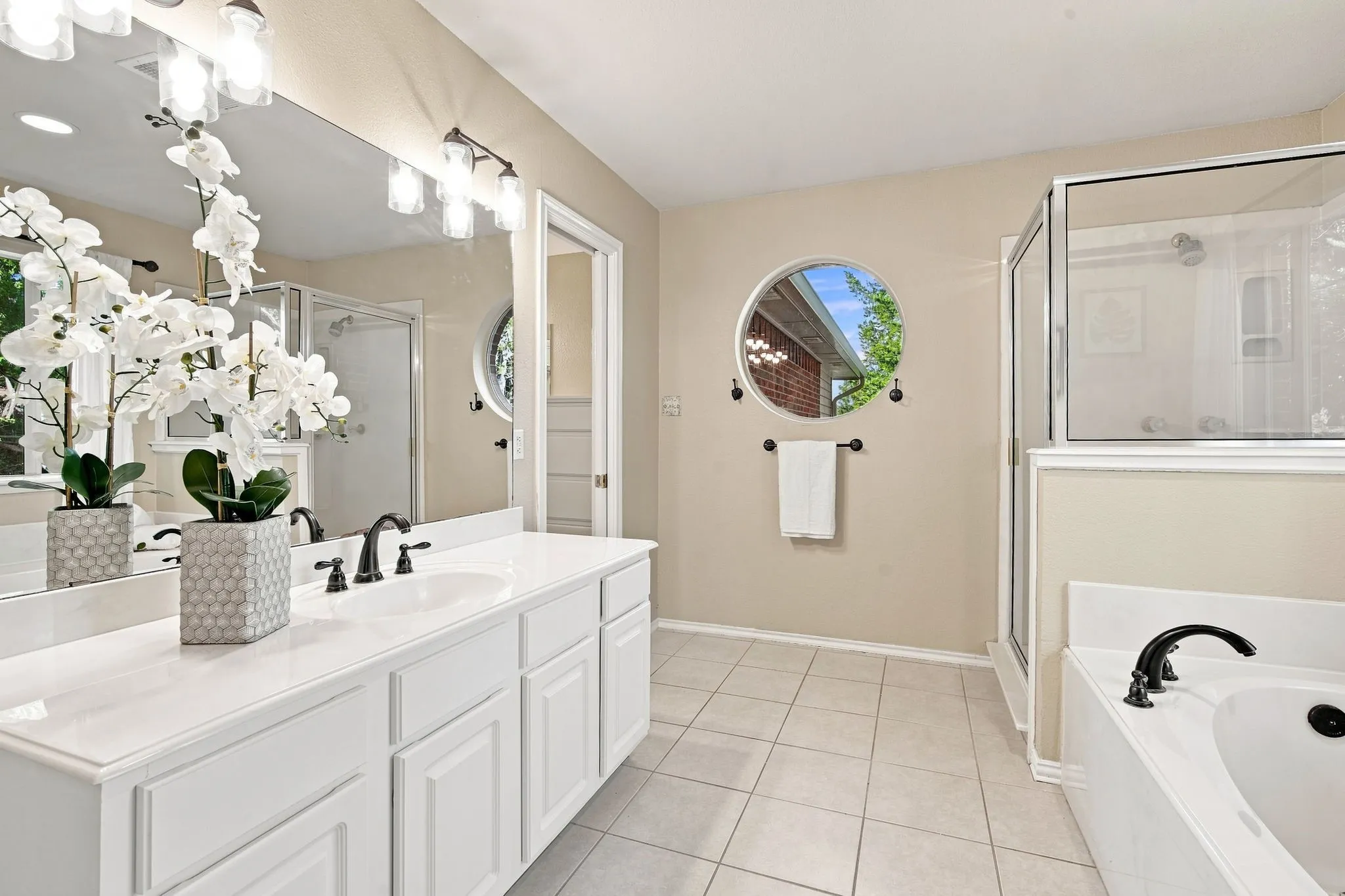 Spacious double vanity bathroom with crisp white cabinetry, polished countertops, and dual undermount sinks.