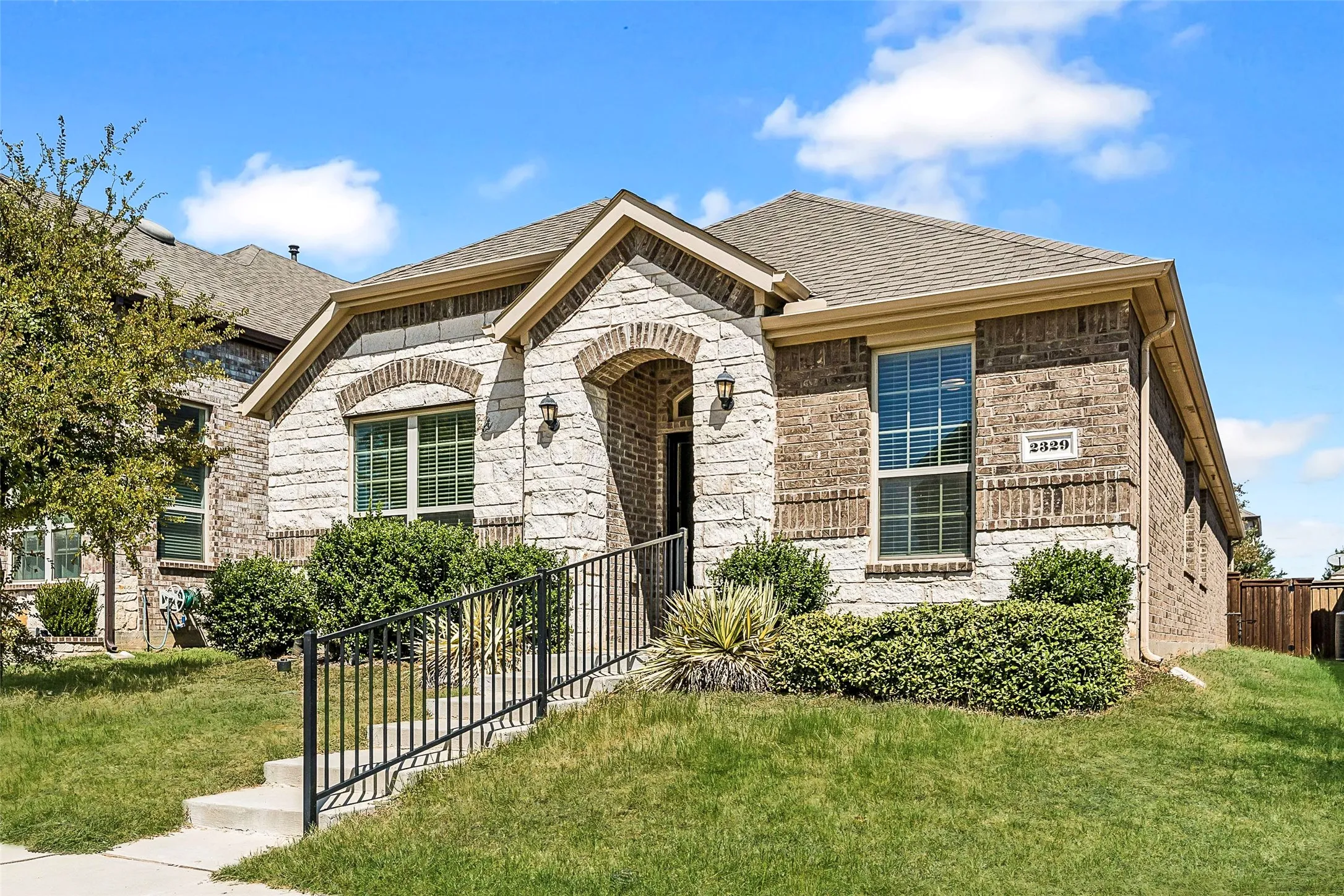 Stone and brick veneer exterior with an arched entry and covered porch