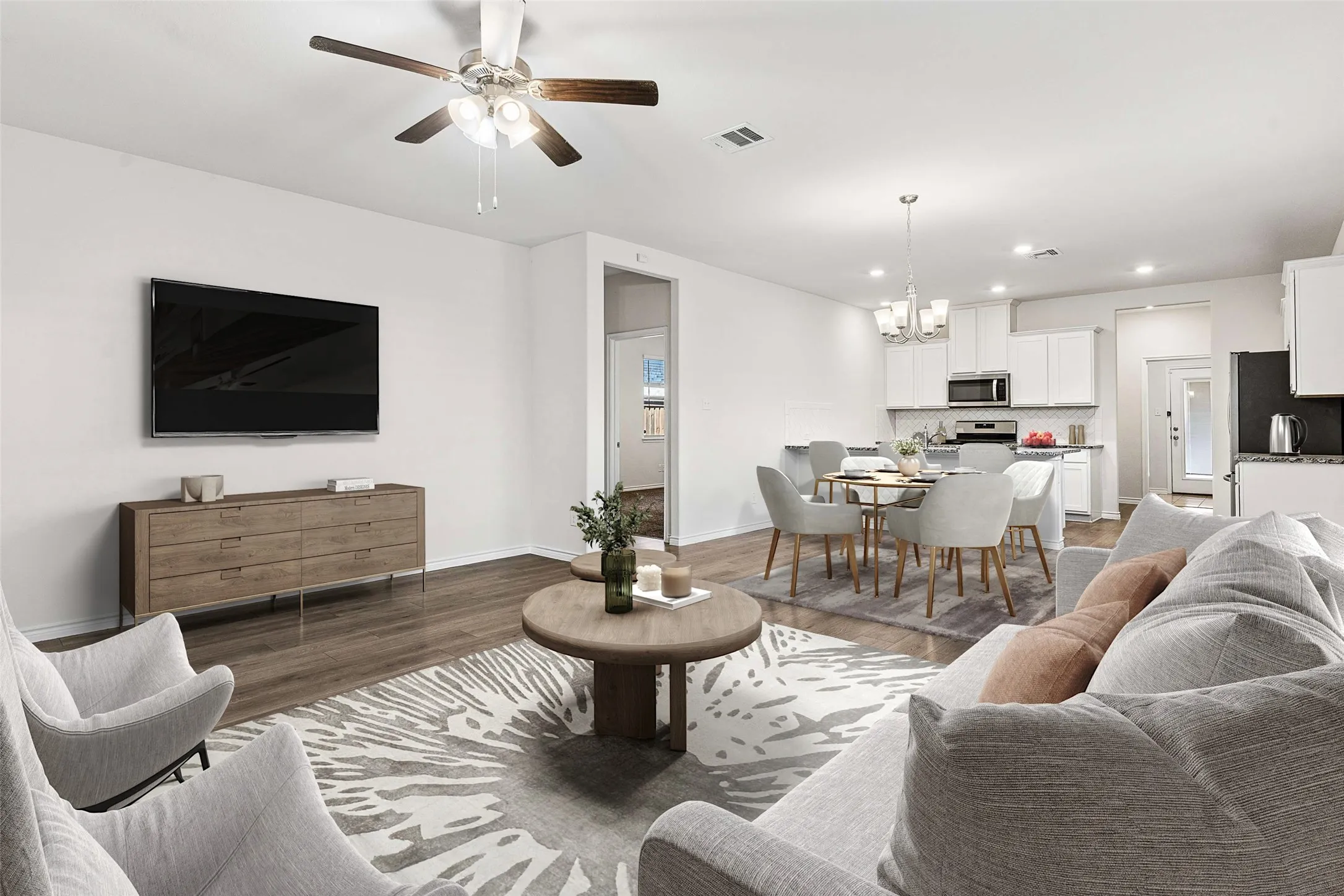 Open-concept living area featuring wood-finish flooring, a ceiling fan with integrated lighting, and recessed lighting