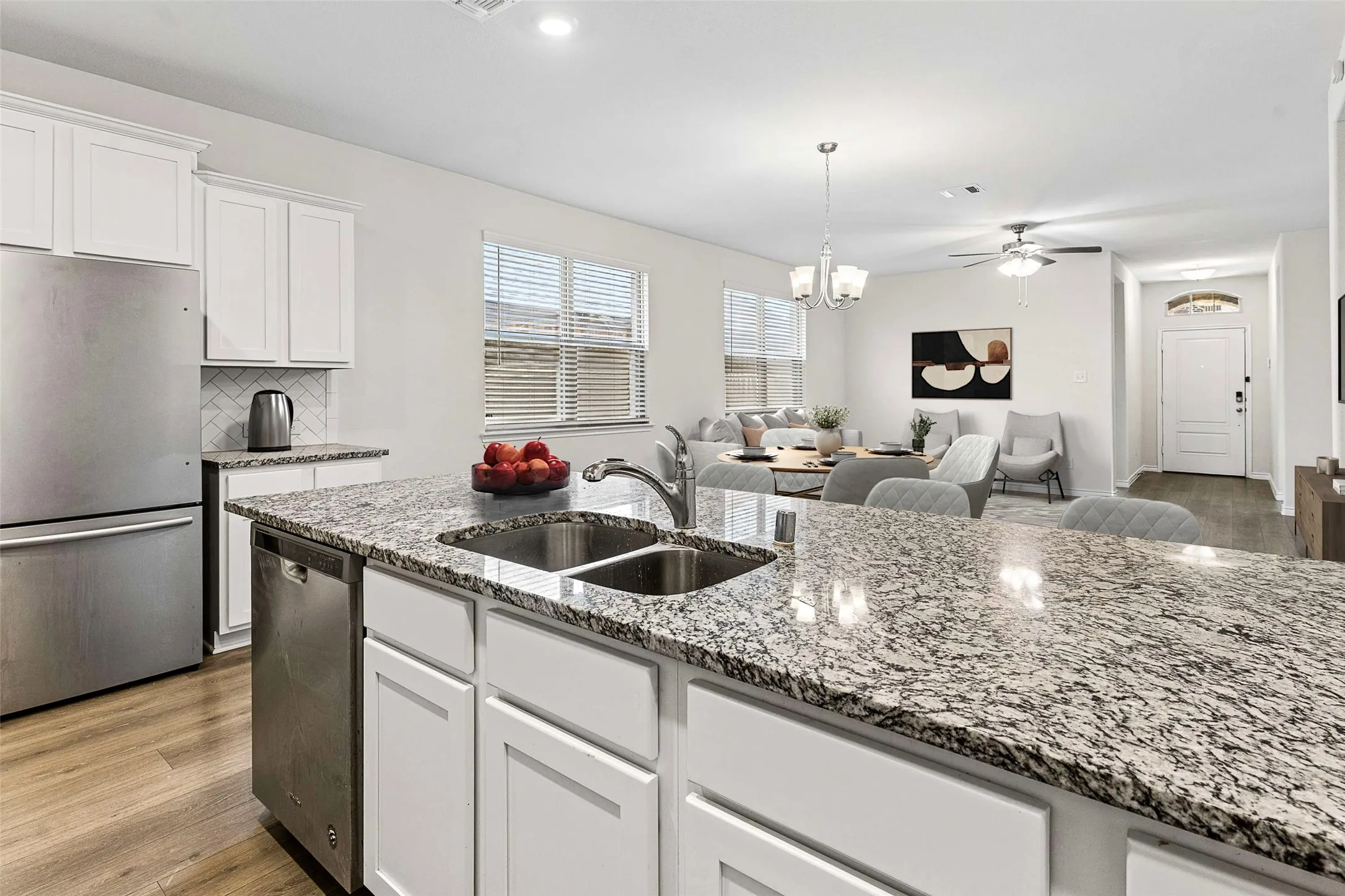 Kitchen island with dual stainless steel sink, stainless steel dishwasher, and granite countertop