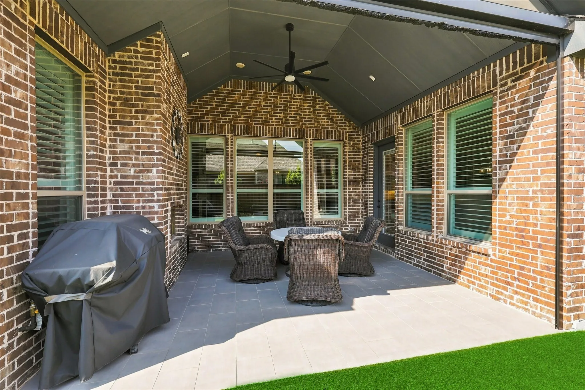 Covered patio with brick construction, ceiling fan, recessed lighting, and tile flooring