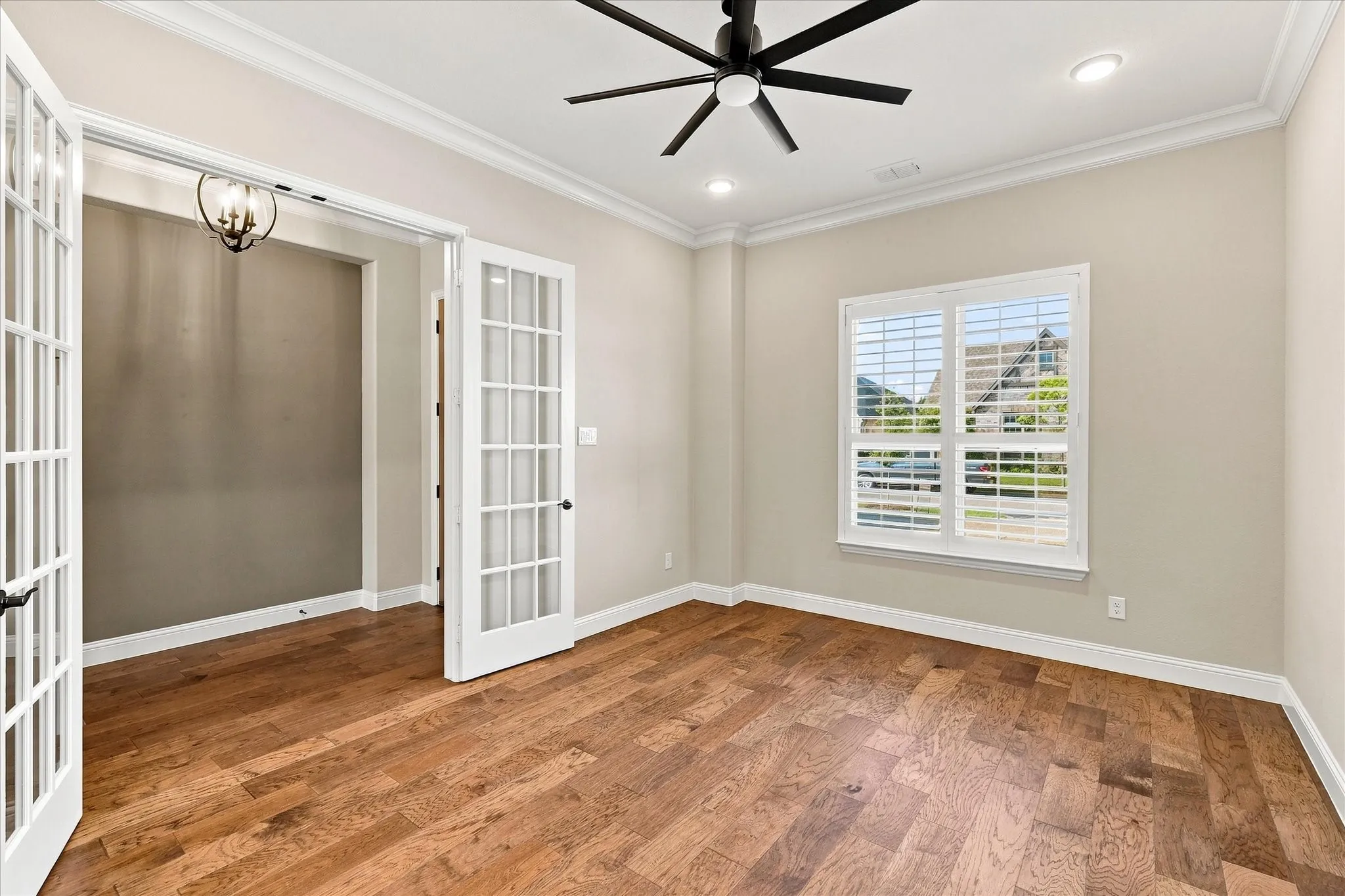 Wood-finish flooring with crown molding and recessed lighting